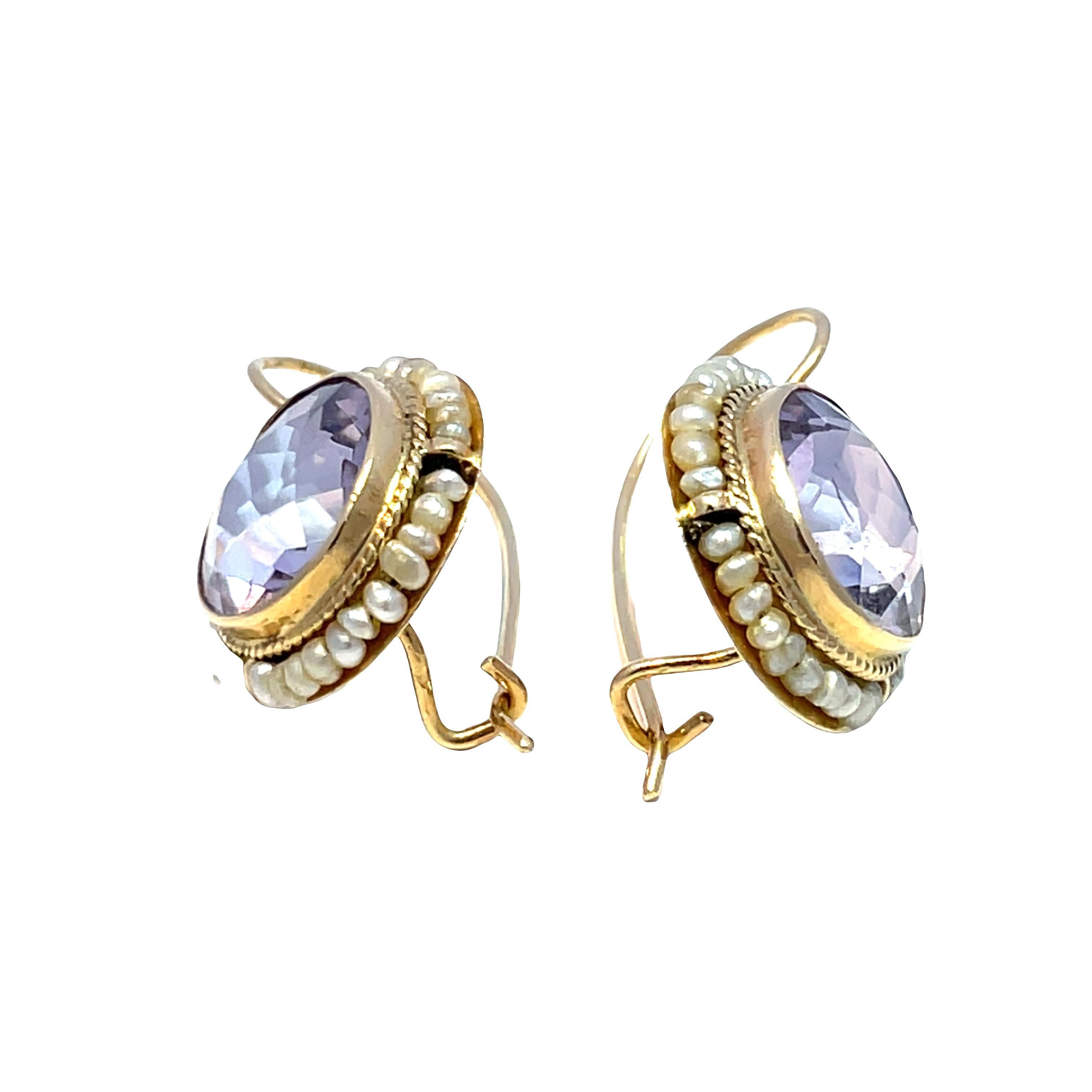 Rehaussez votre collection de bijoux avec ces exquises boucles d'oreilles vintage, ornées de superbes améthystes violettes et de perles lustrées serties dans un luxueux or jaune 14 carats. Pesant au total 4,93 g, ces boucles d'oreilles ne sont pas