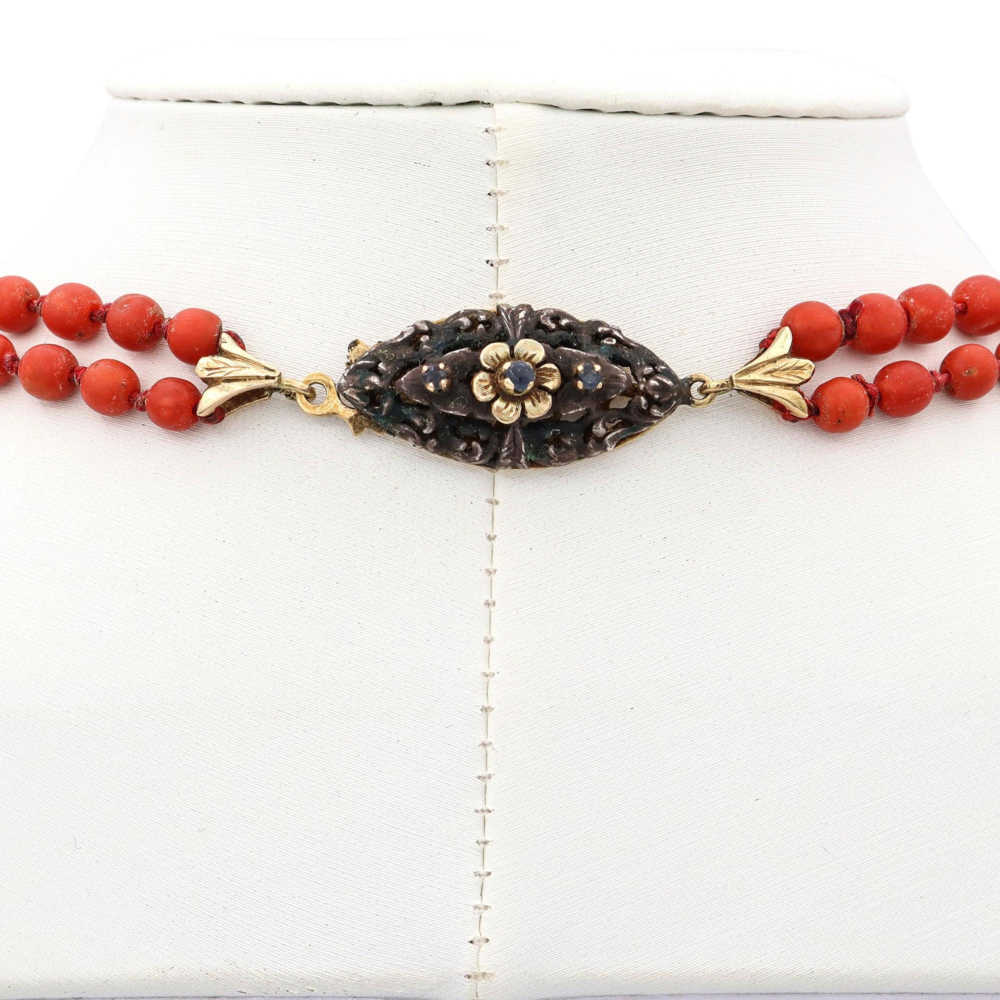 Questa collana antica presenta due fili di ricche perle di corallo naturale, splendidamente contrastate da distanziatori in argento e rifinite con una chiusura in oro giallo 14k. Le calde tonalità corallo e i dettagli in metallo misto creano una