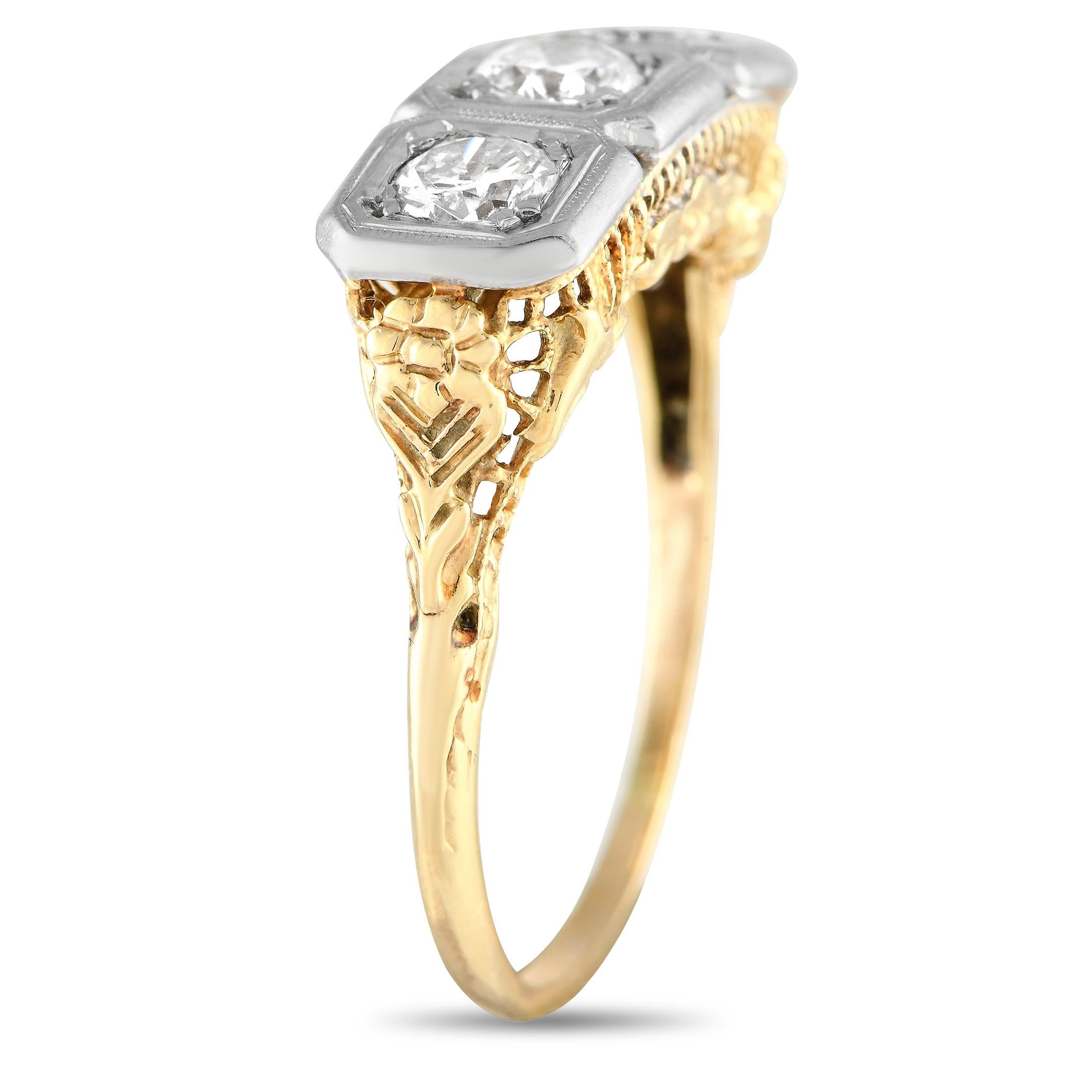 It's hard not to swoon over this alluring antique trilogy ring. It features a 14K yellow gold band with a delicate 1mm-thin shank and elaborately decorated shoulders. Sitting atop the intricate gallery are three round diamonds, each flush-set on a