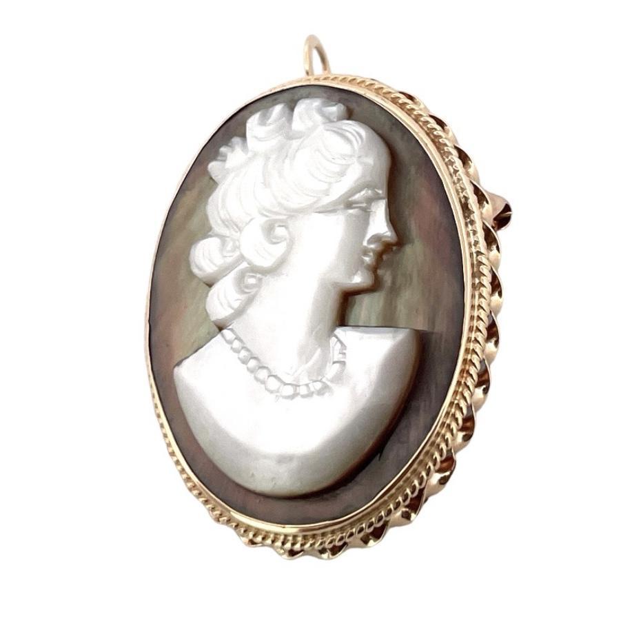 Discover the timeless beauty of this vintage carved mother of pearl cameo brooch pendant. Crafted from exquisite 14K yellow gold and weighing 6.07 grams, this brooch exudes elegance and sophistication. The delicate detailing on the cameo adds a