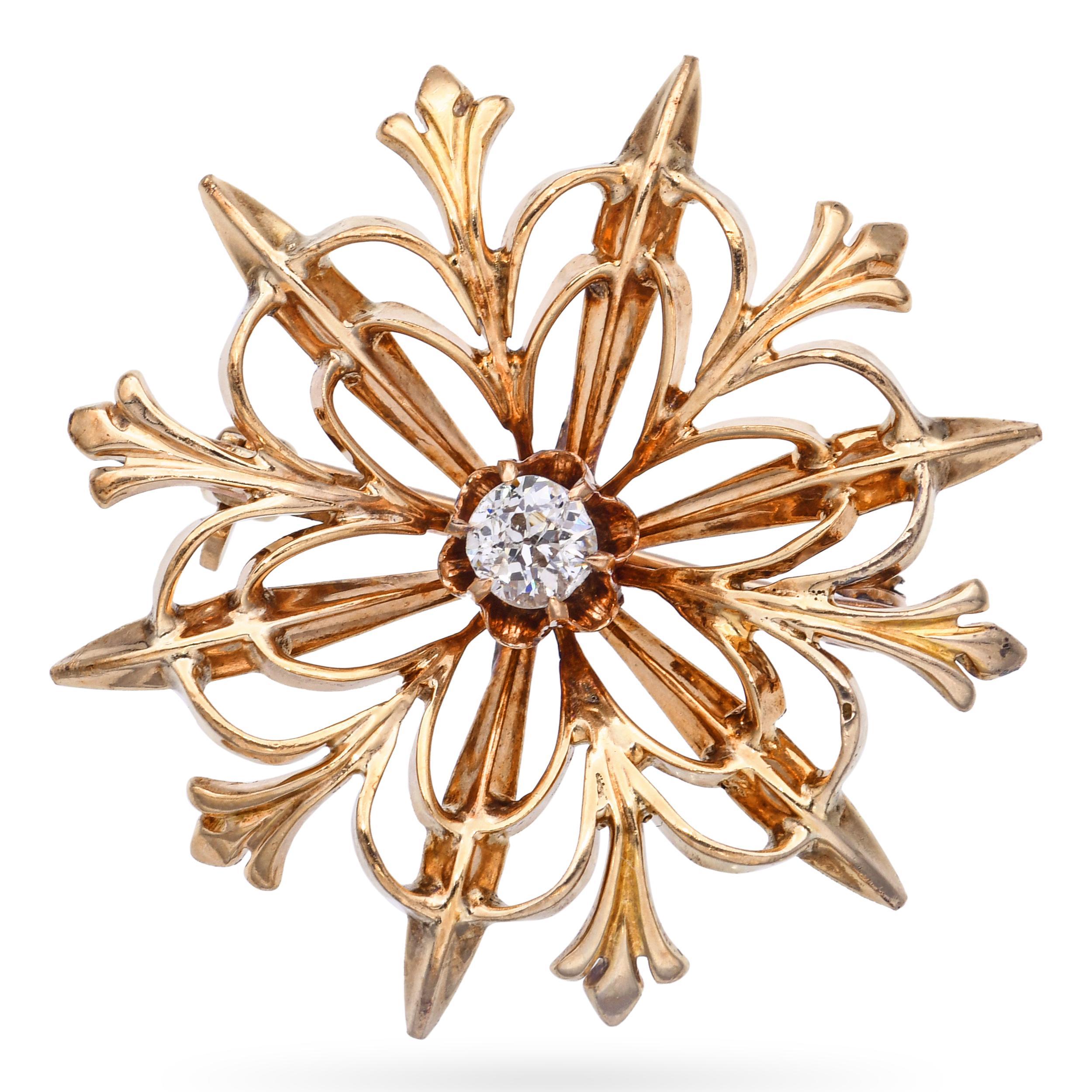 Cette broche ancienne est réalisée en or jaune 14 carats et présente un charmant motif de fleur ou d'étoile. En son centre trône un diamant étincelant de 0,15 carat, ajoutant une touche de brillance aux élégants pétales sculptés. Le Design/One allie