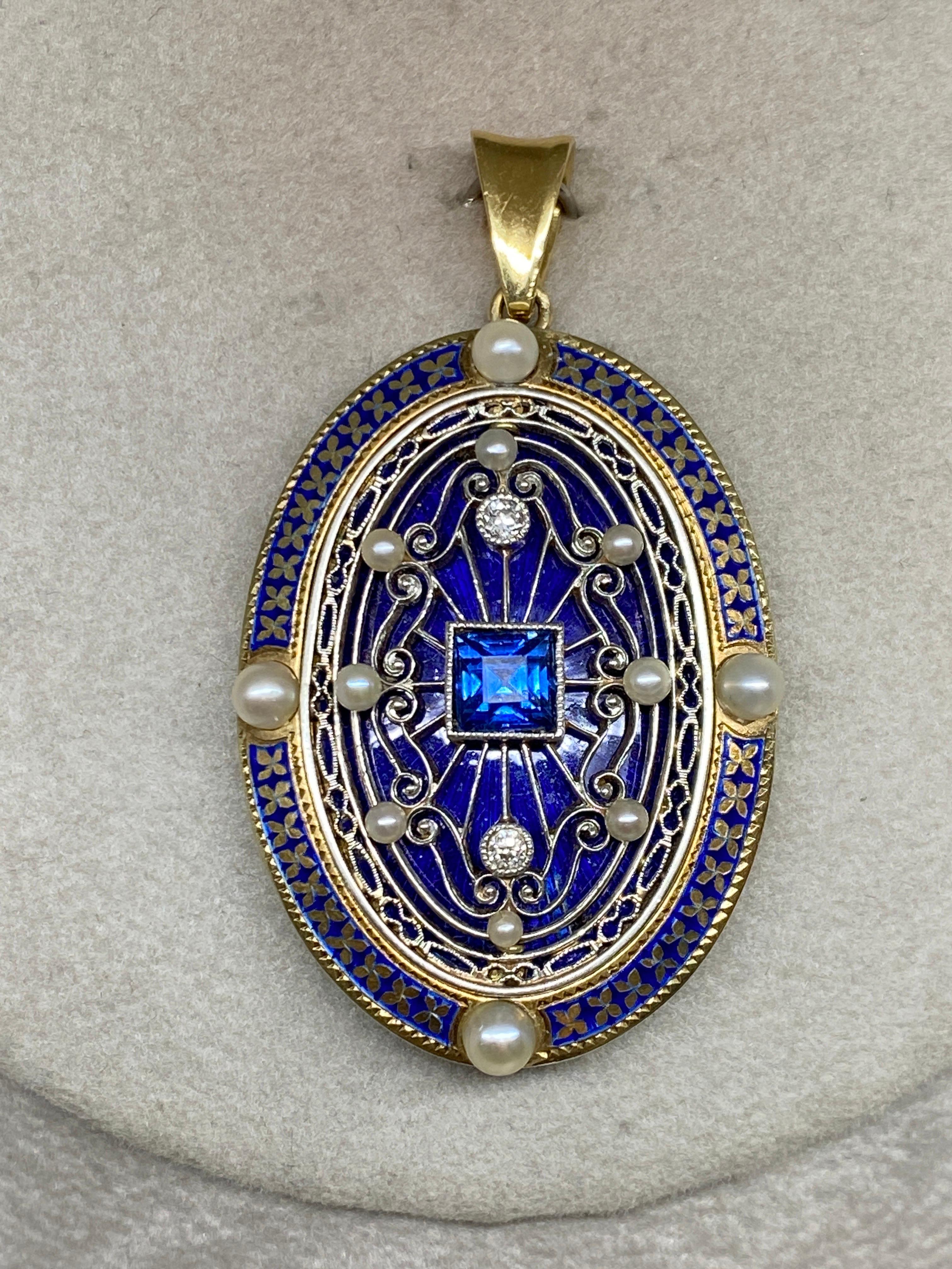 This stunning 14k yellow gold piece circa early 1900's was originally a brooch and at some point during it's past was elegantly converted into an alluring pendant.

At the center of a glossy ultramarine blue enameled oval yellow gold plaque sits a