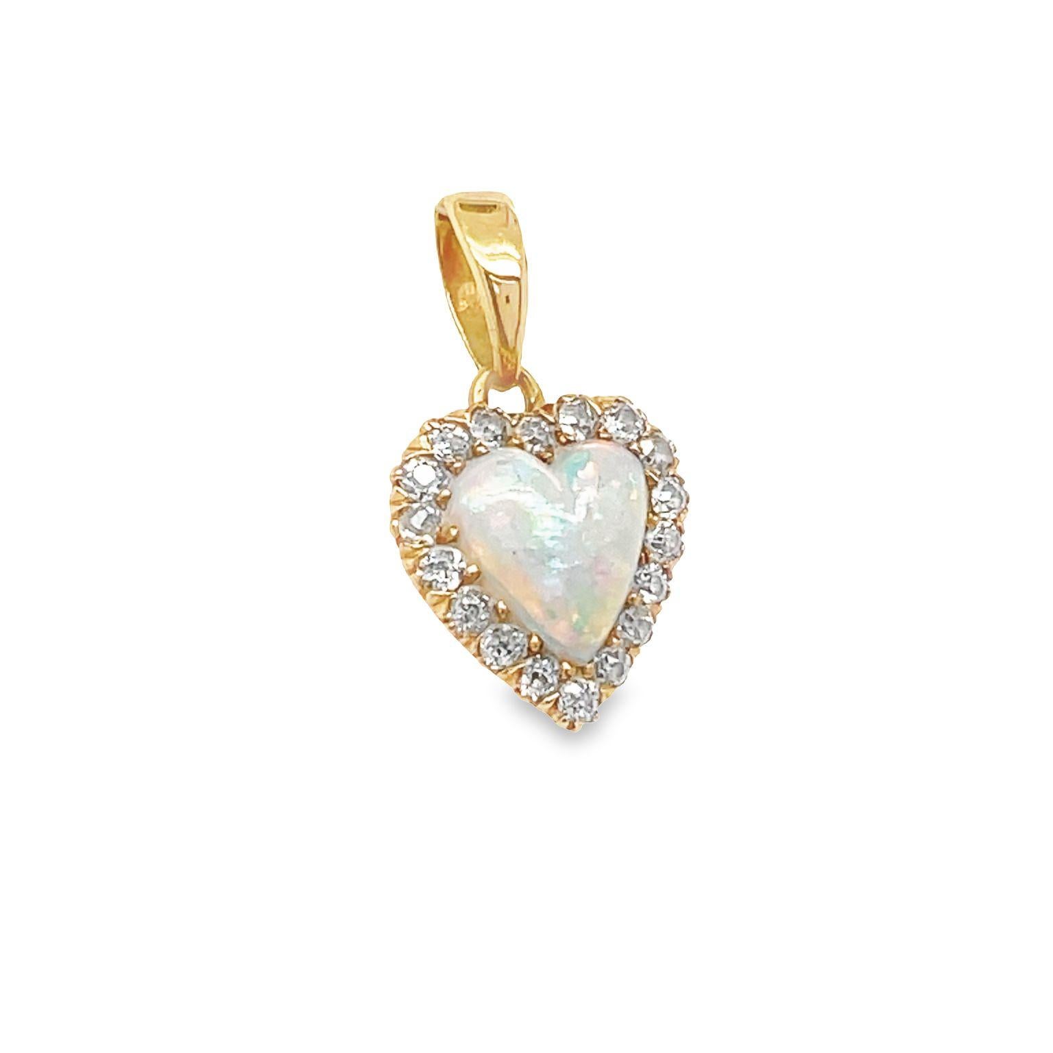 This beautiful and elegant antique 14k yellow gold pendant showcase a beautiful heart shaped opal framed in a halo of diamonds. The natural opal heart weighs approximately 0.80 carat and is encircled by old mine cut diamonds weighing around 0.30