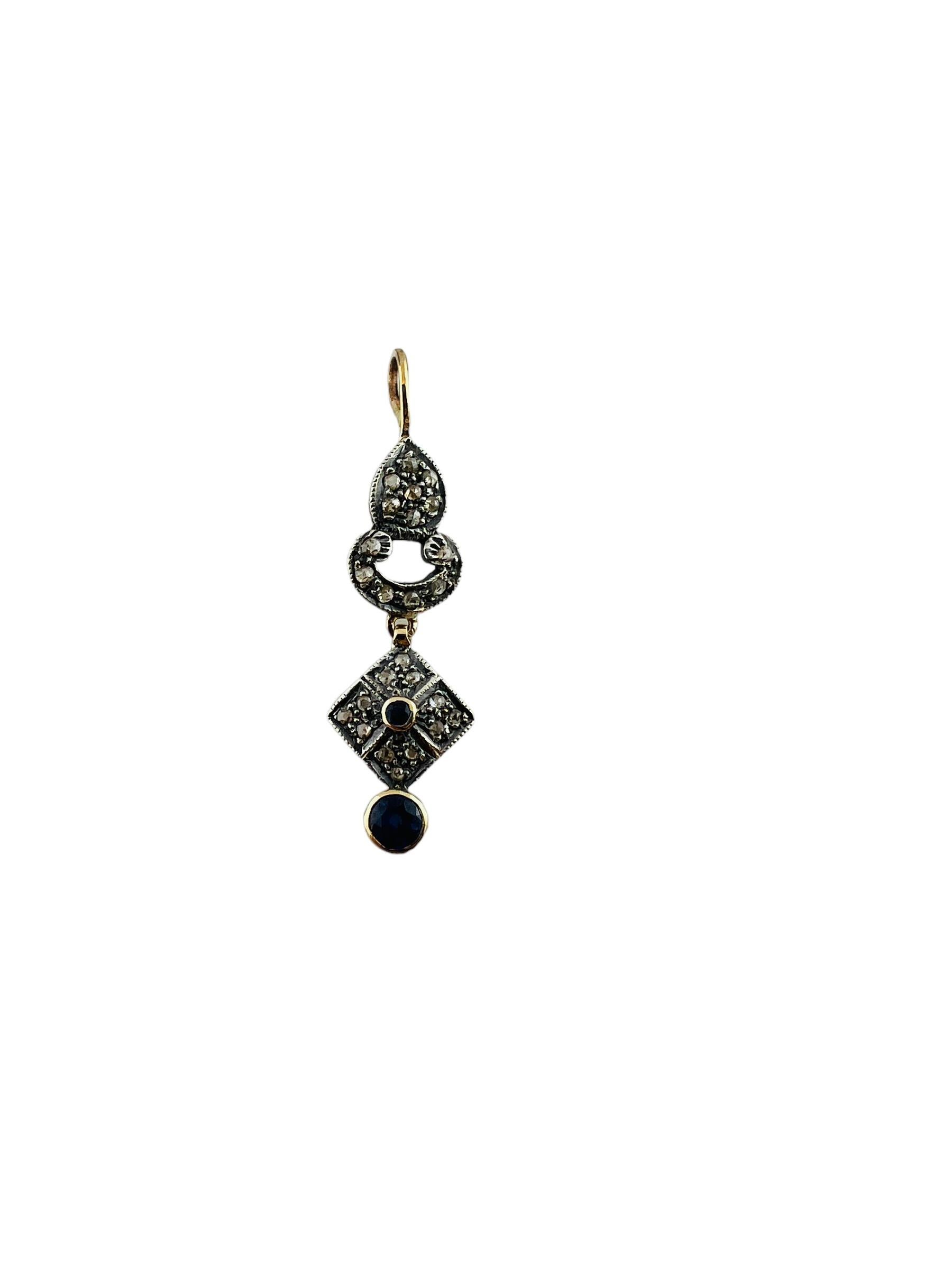 This delicate dangling pendant is set in 14K yellow gold with silver on top ( as was common for its time period)

The pendant is set with 25 rose cut diamonds of SI1-I1 clarity and I color

Pendant also has 2 bezel set synthetic faceted blue