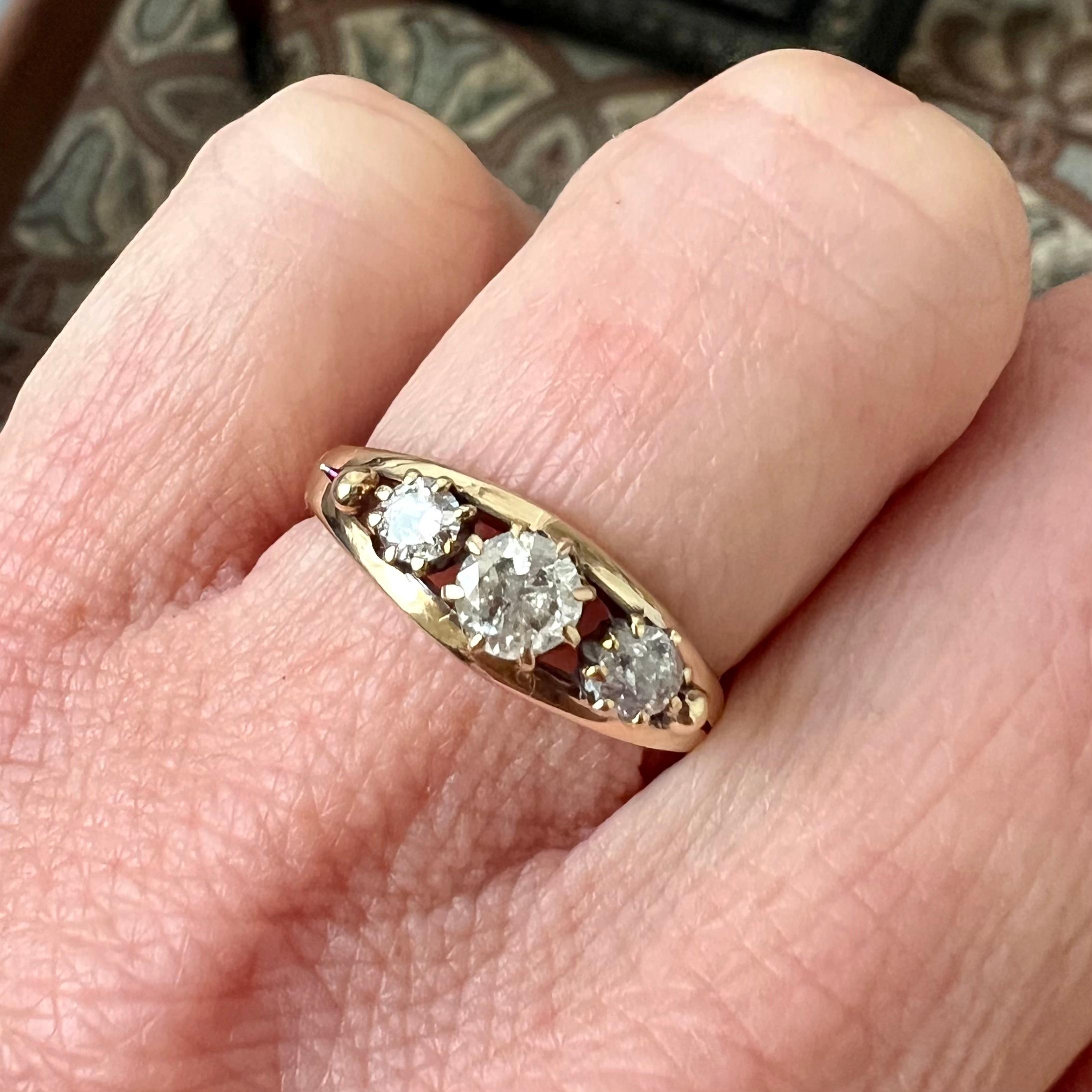 Un pezzo di eleganza senza tempo, questo anello antico è realizzato in caldo oro 14 carati e mette in mostra tre scintillanti diamanti taglio vecchio Europa, incastonati in una classica montatura a griffe (chaton). Con un peso totale di circa 0,60