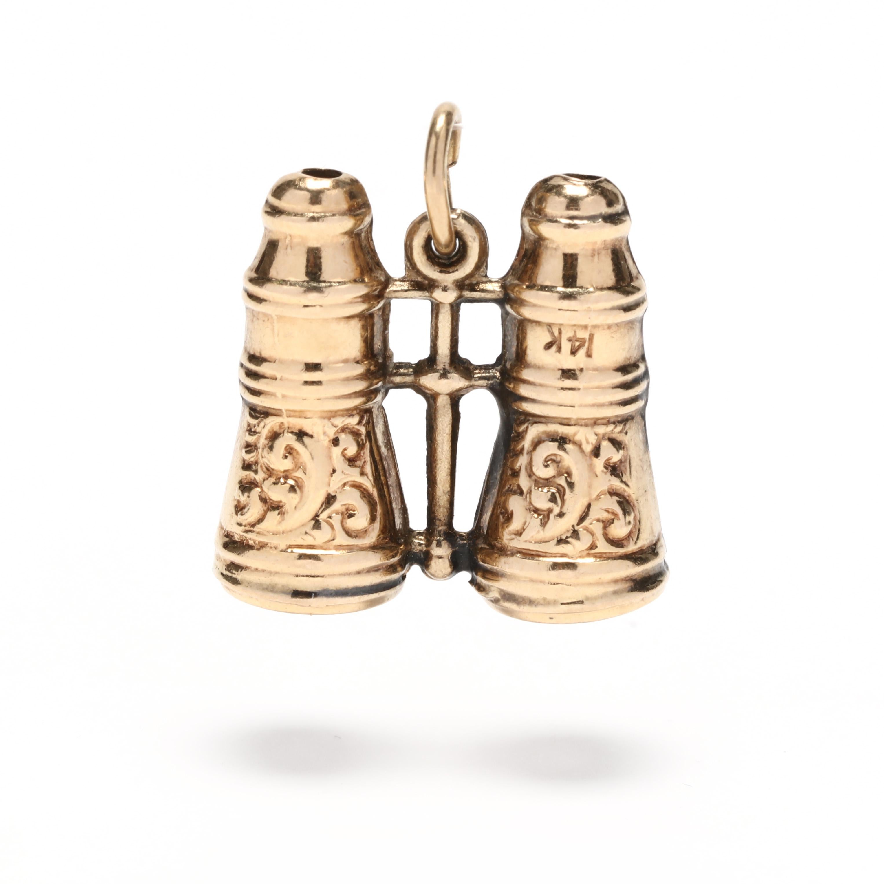 A antique 14 karat yellow gold engraved binoculars charm / pendant.  Of Victorian era, a pair of ornately engraved binoculars with a swirl motif and suspended from a thin oval bail.

Length: 3/4 in.

Width: 3/4 in.

2.9 dwts.

A Couple Of Things to