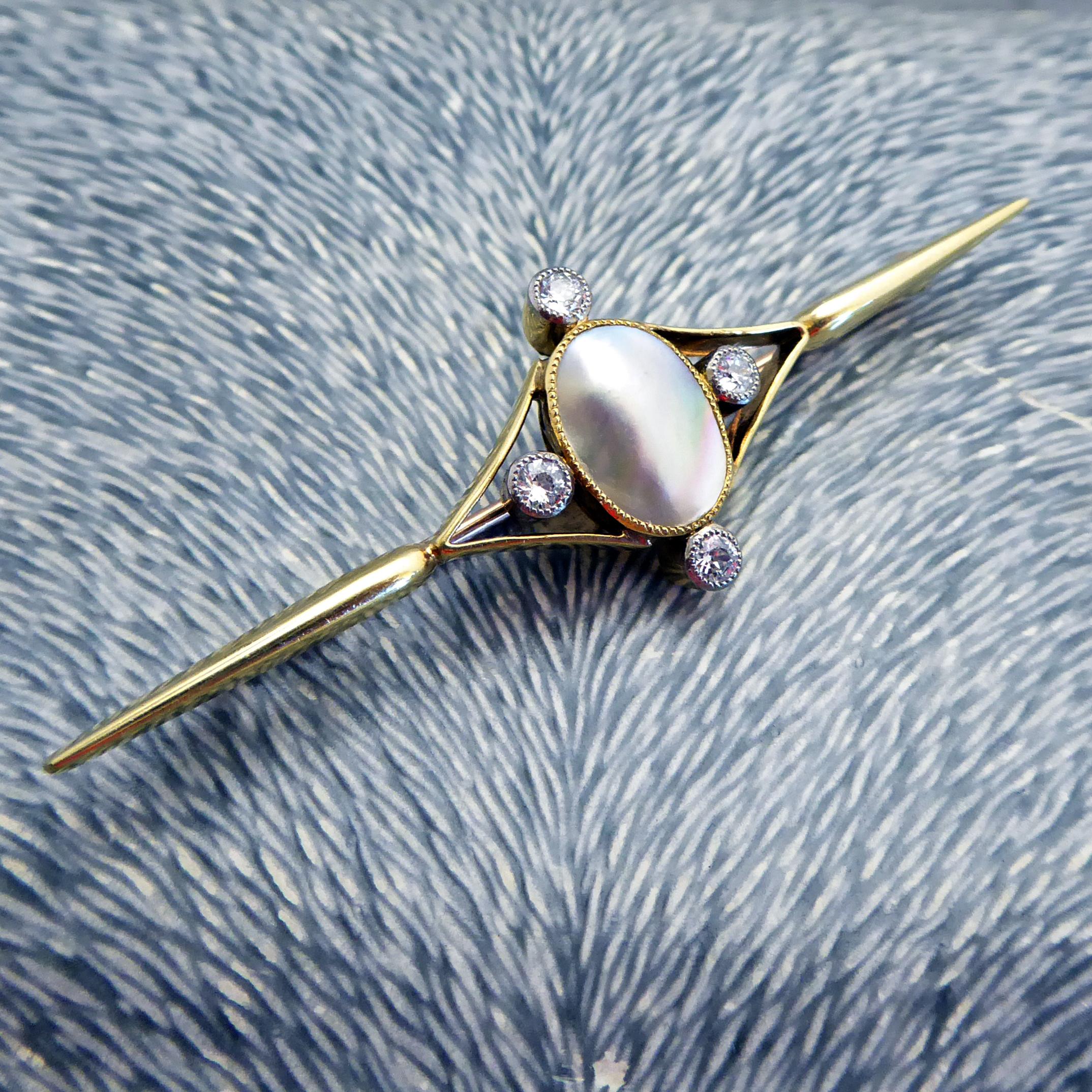 An exquisite pearl and diamond brooch in the Art Nouveau style.  A Mabe pearl measuring some 11.00mm x 8.00mm is in a millegrain edged mount to the centre of a marquise shaped open panel.  Evenly spaced around the pearl are four old diamonds, each