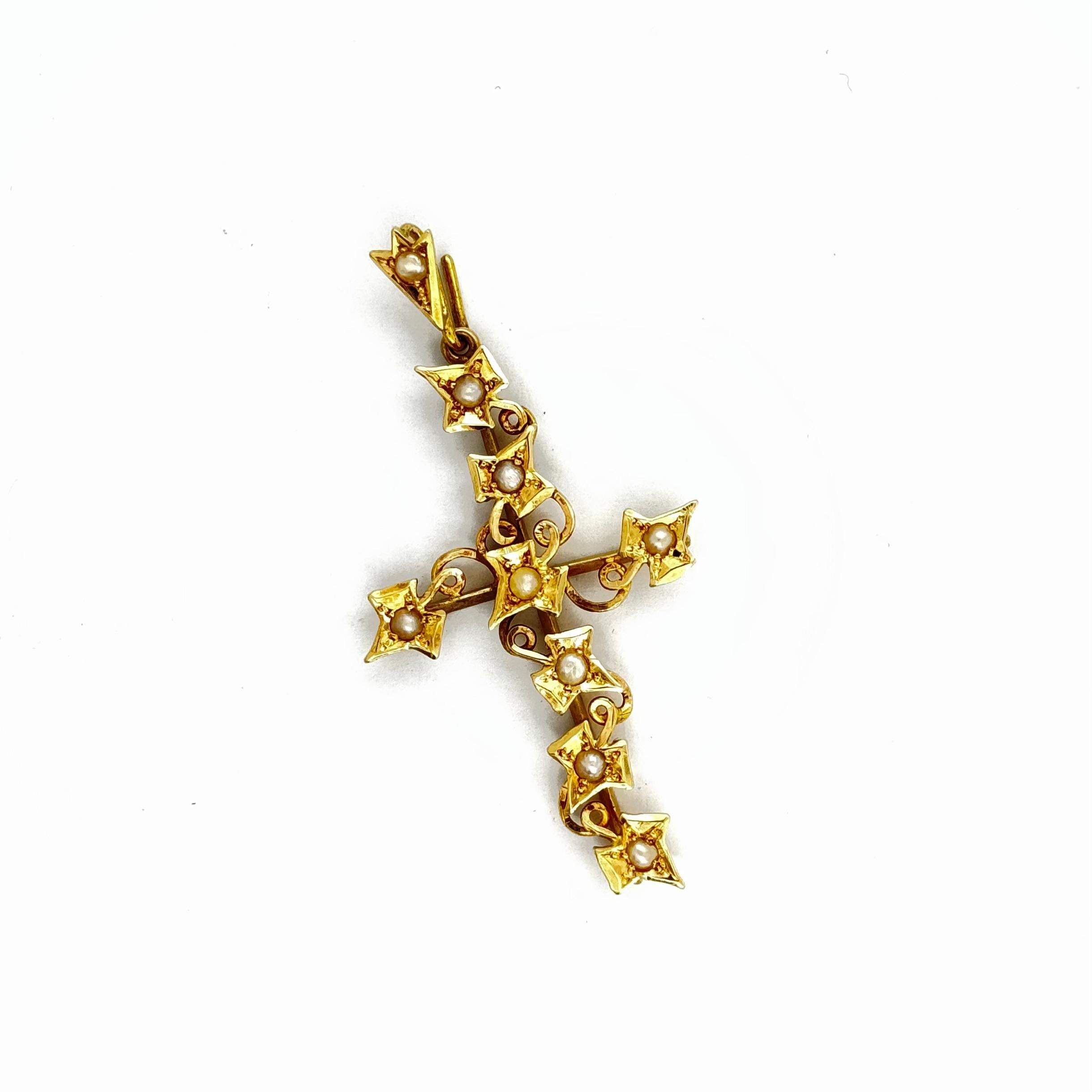 Cette croix unique en or jaune 15 carats antique est ornée d'un ravissant motif de feuilles de lierre gravé à la main qui serpente de haut en bas. Une petite perle de rocaille blanche naturelle est placée dans chaque feuille.
La longueur de la croix