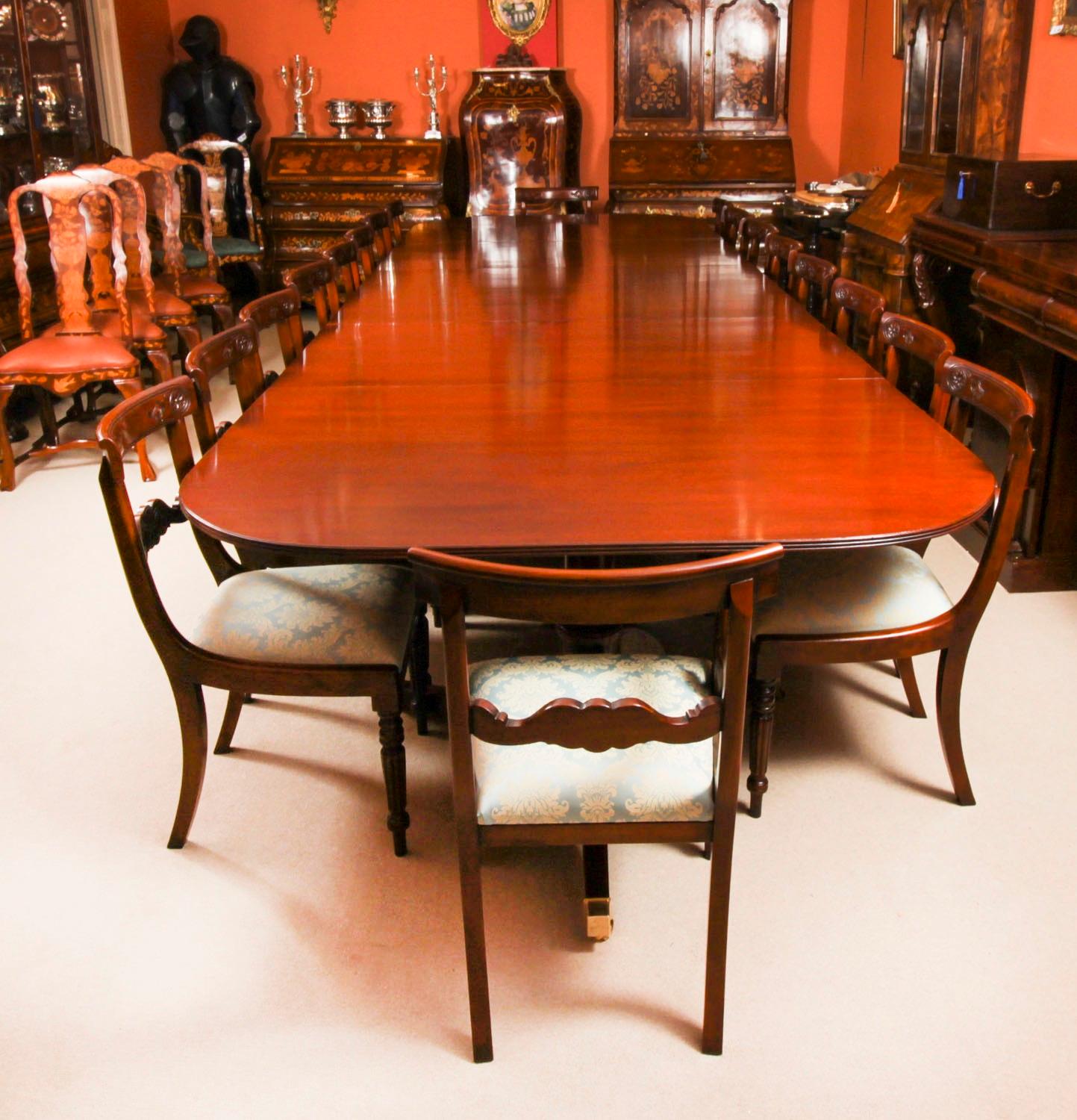 This is  fabulous  dining set comprising an antique George III style triple pedestal dining table Circa 1920 in date, and a superb Vintage set of eighteen bar back dining chairs, mid 20th Century in date

The rounded cornered table top is made from