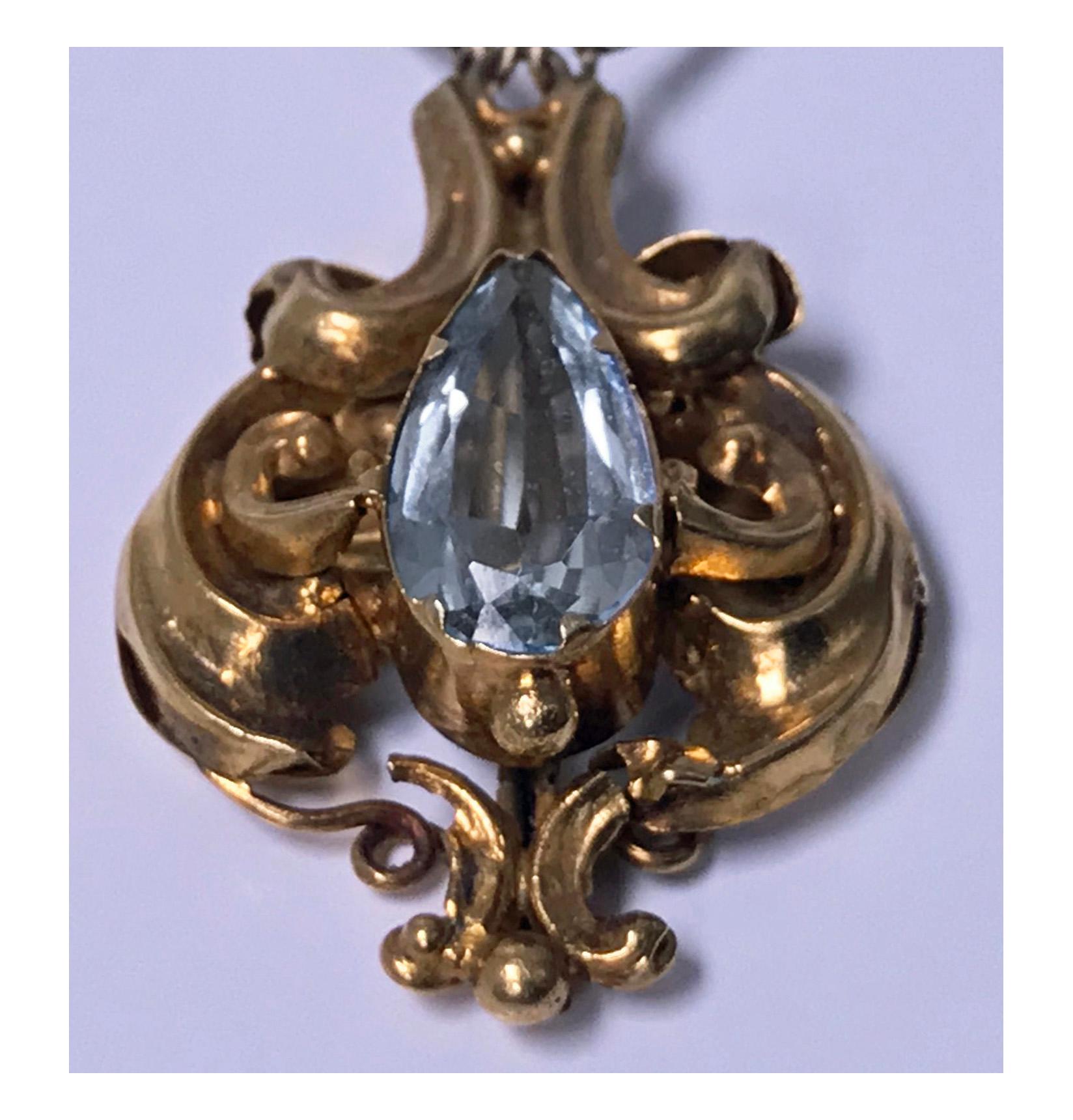 Antique 15K Aquamarine brooch, English C.1840. The open scroll foliate design upper section set with five oval facetted aquamarines, suspending scroll foliate drop pendant section set with a tear drop aquamarine, chain sections attached. The reverse