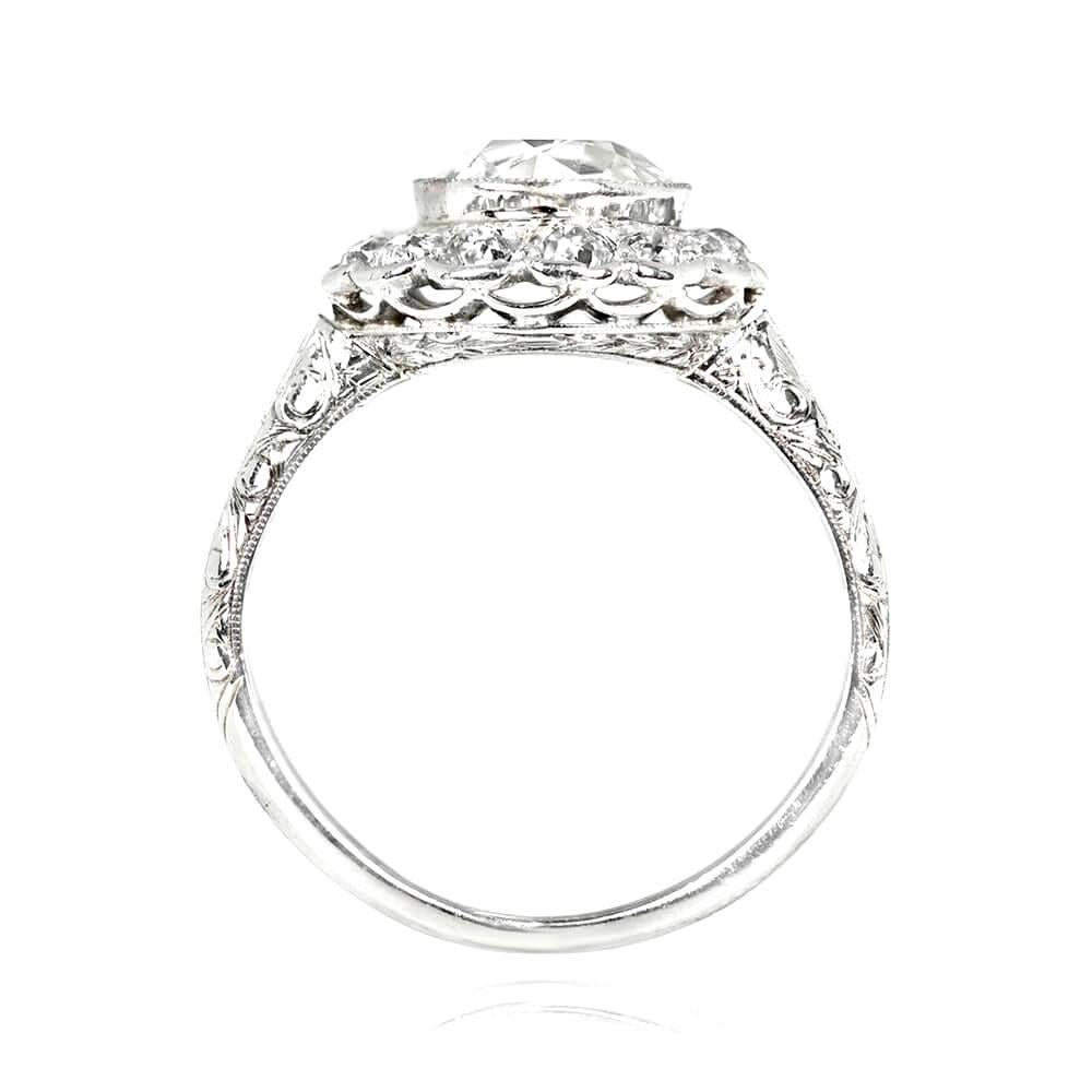 An Edwardian cluster ring featuring a 1.52 carat old European cut diamond, surrounded by a floral halo of old mine cut diamonds weighing 0.65 carats total. The platinum setting boasts an openwork under-gallery, intricate hand-engravings, and fine