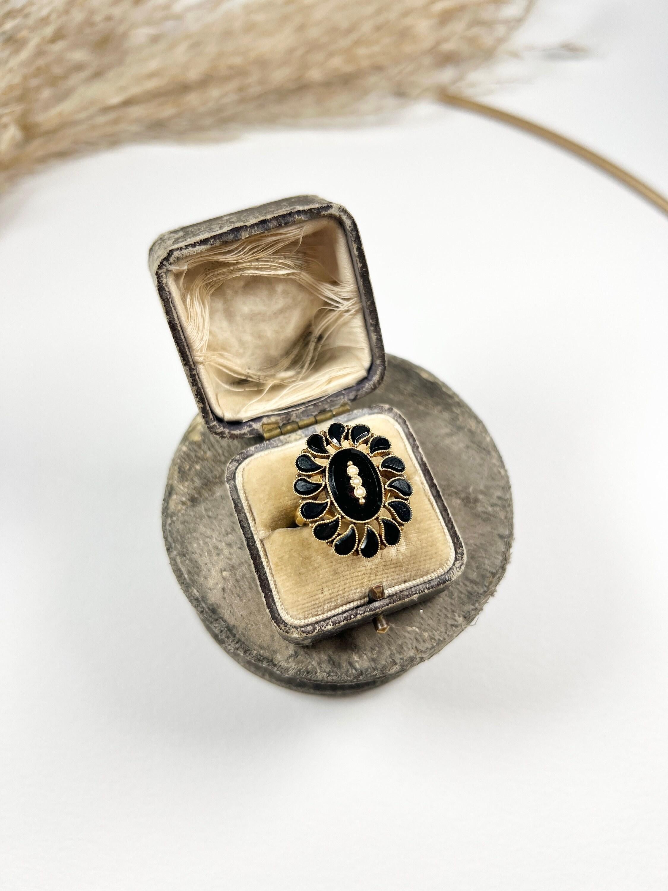 Antique Onyx Ring

15ct Gold Stamped 

Circa 1920s 

This stunning 15ct gold ring from the 1920s features an onyx centre stone adorned with three bezel-set natural seed pearls and a gold ball on either end. The ring is further embellished with a