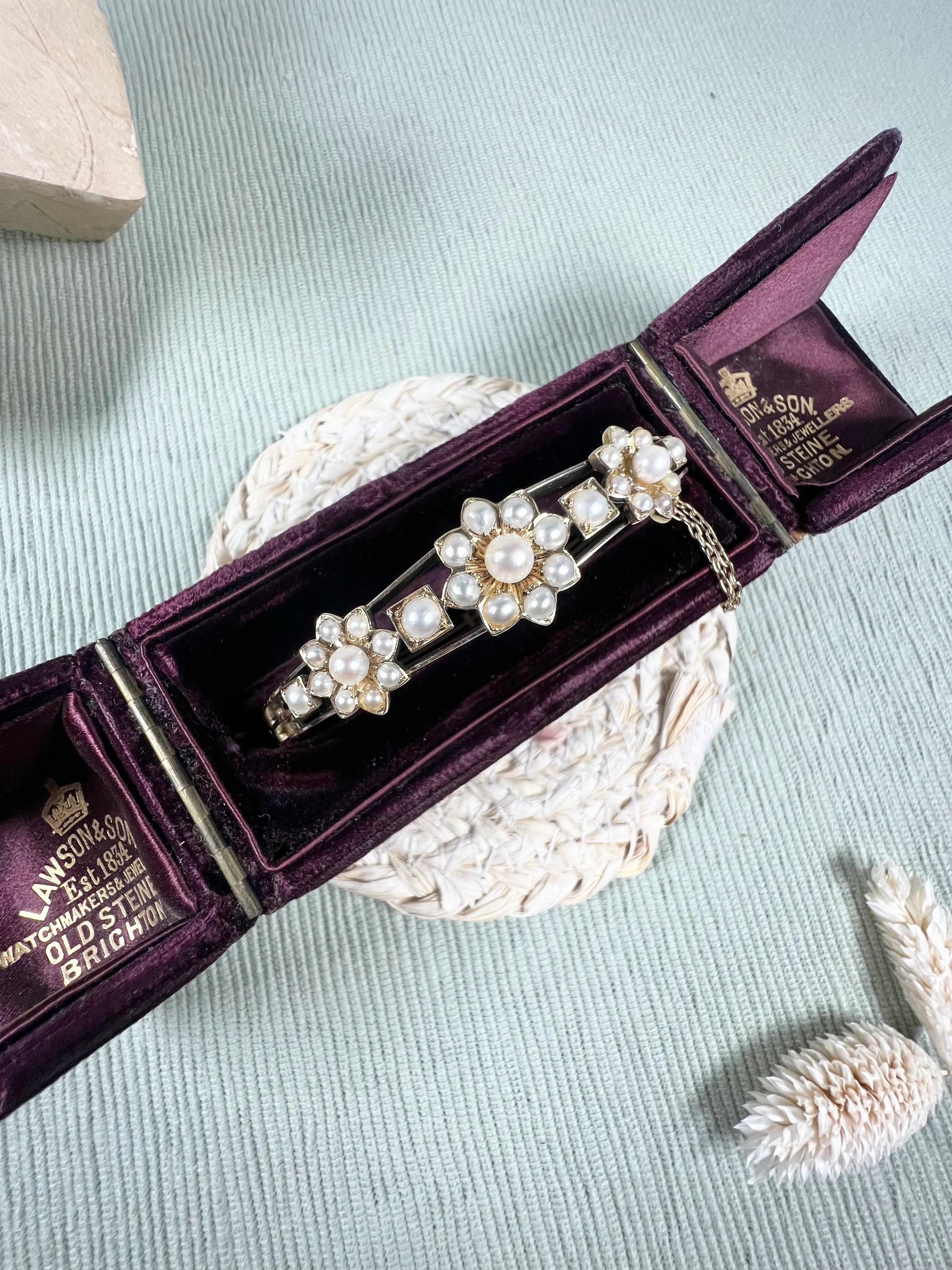 Antique Pearl Bangle 

15ct Gold Tested 

Circa 1900

Fabulous, Edwardian yellow gold bangle set with gorgeous, natural, seed pearl stones. The centre piece features three beautiful, pearl set flowers- mounted on a lovely open work gold bangle. The