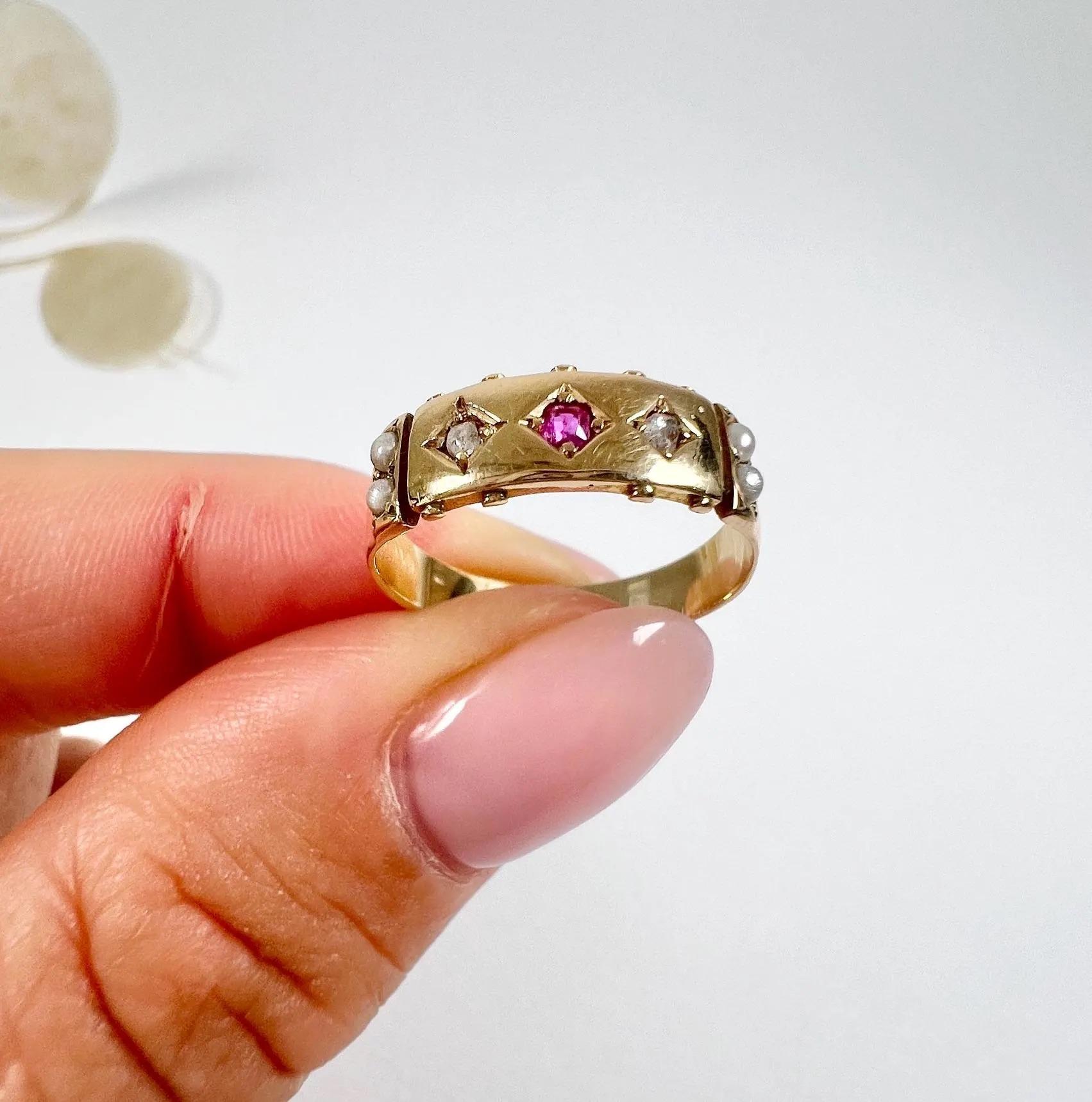 Antique Band Ring

15ct Gold Tested

Circa 1910

Introducing a stunning 15ct yellow gold band with exquisite details. This beautiful band features a captivating centre ruby, elegantly flanked by a rose-cut diamond on each side. The shoulders of the