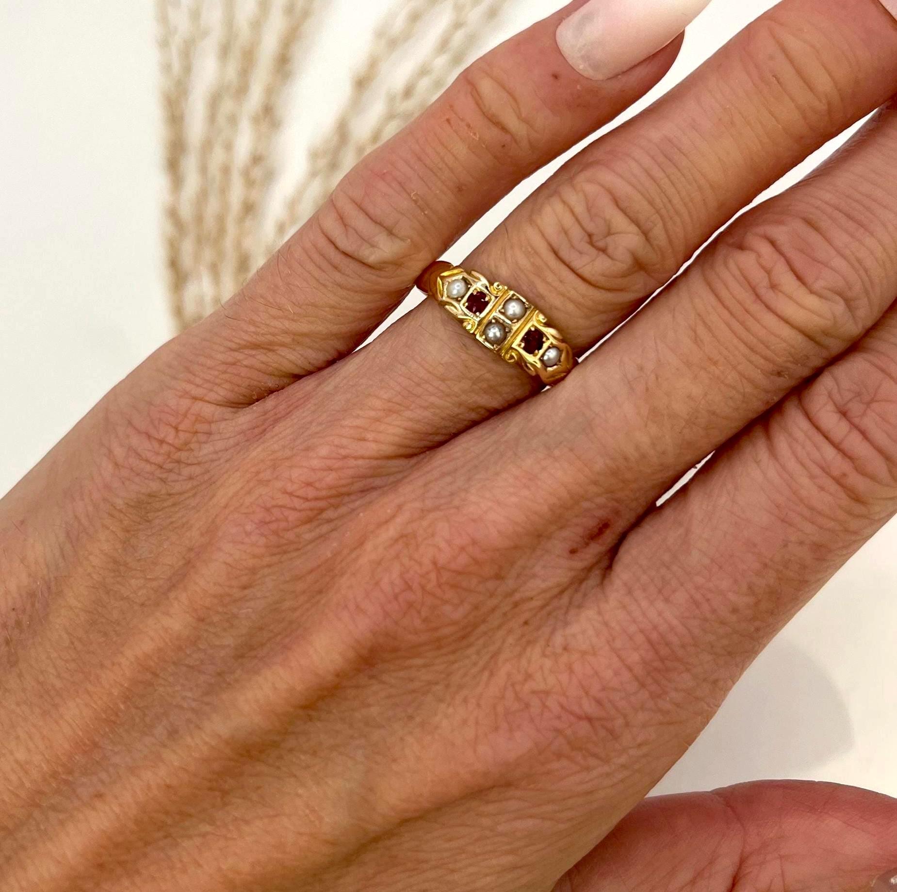 Bague gitane ancienne en rubis et perles 

Poinçonné en or 15ct 
Chester 1894

Fabriqué en or jaune 15ct avec un ton antique chaleureux. La tête présente quatre perles naturelles et deux rubis de taille ronde dans une disposition linéaire alternée.