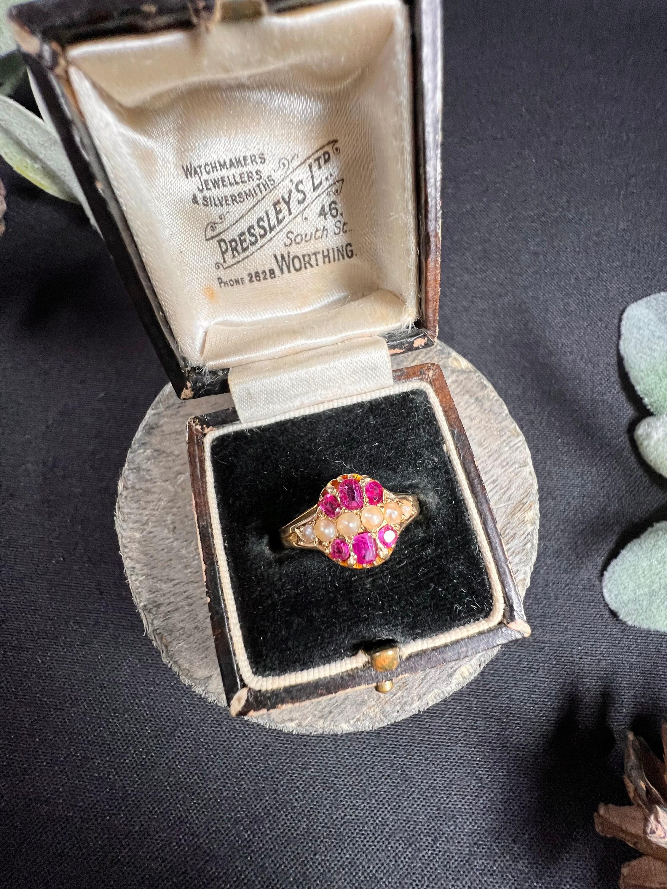 Antique Pearl & Ruby Ring

15ct Gold Stamped

Hallmarked Birmingham 1874

Makers Mark W G

This exquisite Victorian ring is crafted from 15ct yellow gold and features six lustrous seed pearls arranged elegantly across the centre of the band. The