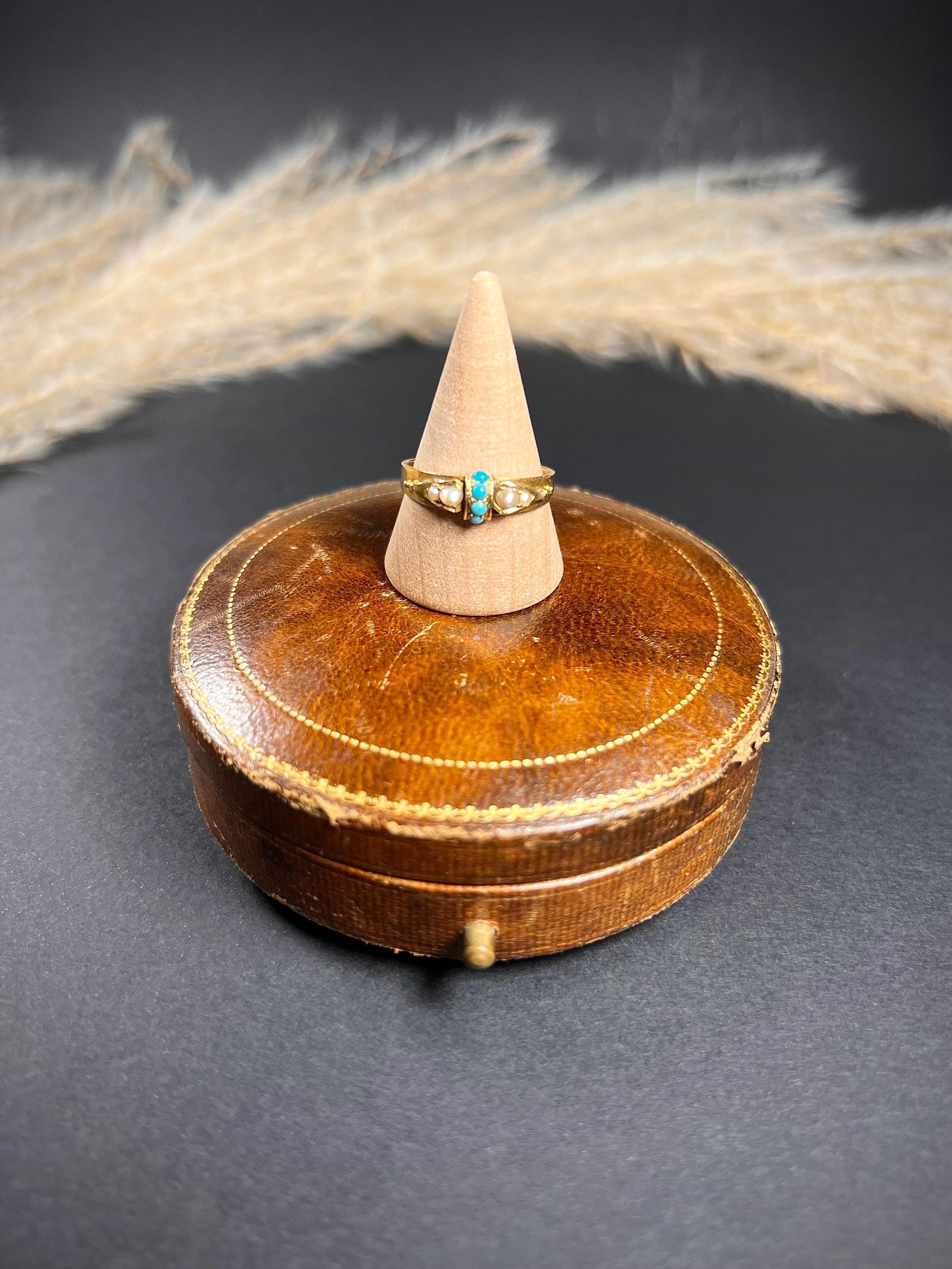 Antique Ring 

15ct Gold Stamped 

Hallmarked Birmingham 1868

Lovely, Victorian gold ring. Set with four centre turquoise stones & two natural seed pearls either side. The stones are mounted in an 15ct yellow gold, tapered band. 

The ring has ‘M