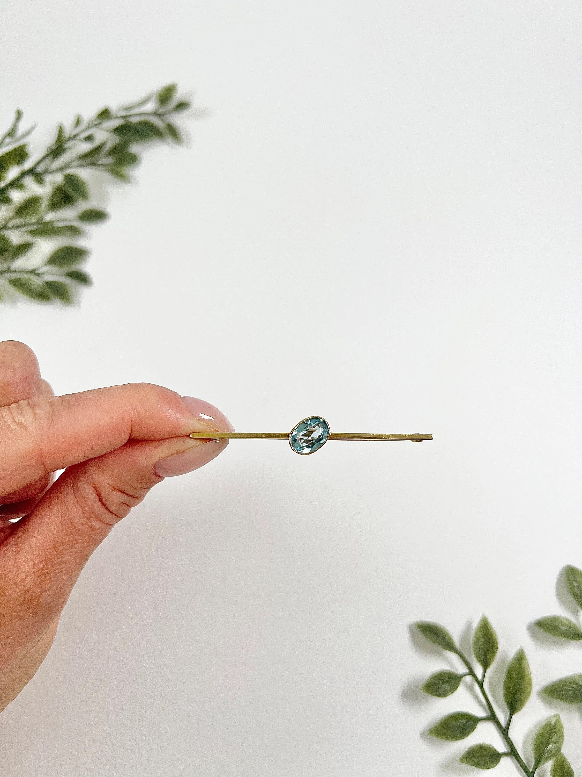 Antique Gold Brooch

15ct Gold Tested

Circa 1910

This exquisite Edwardian bar brooch is crafted from 15ct yellow gold and features a stunning oval faceted aquamarine. The 15ct stamp has rubbed, so the brooch has been acid-tested to confirm the