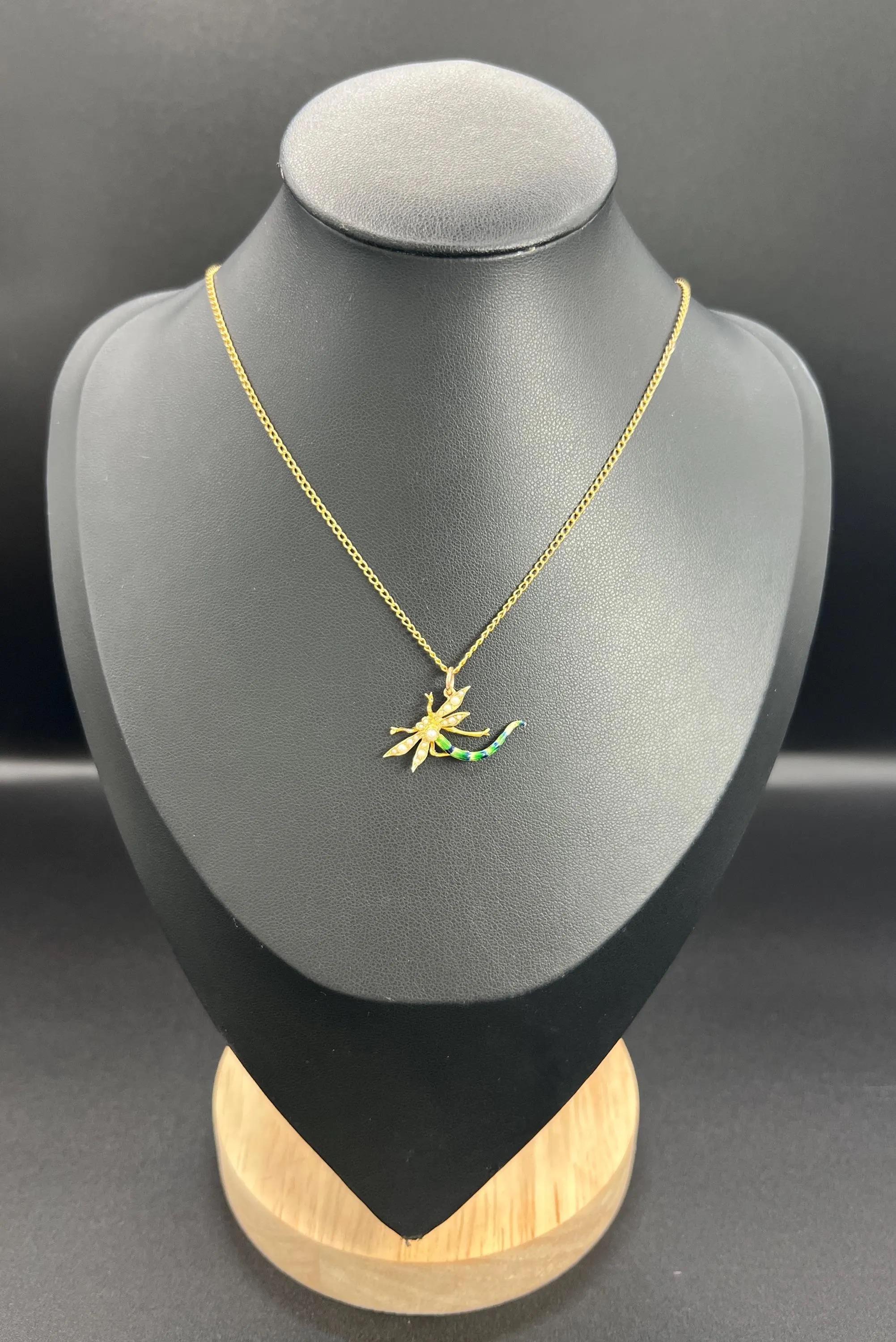 Antique Dragonfly Necklace

15ct Gold Tested

Circa 1910

This stunning pendant exemplifies Edwardian elegance. Made from 15ct gold, it features a body and wings adorned with seed pearls, along with a beautifully striped tail in green and blue