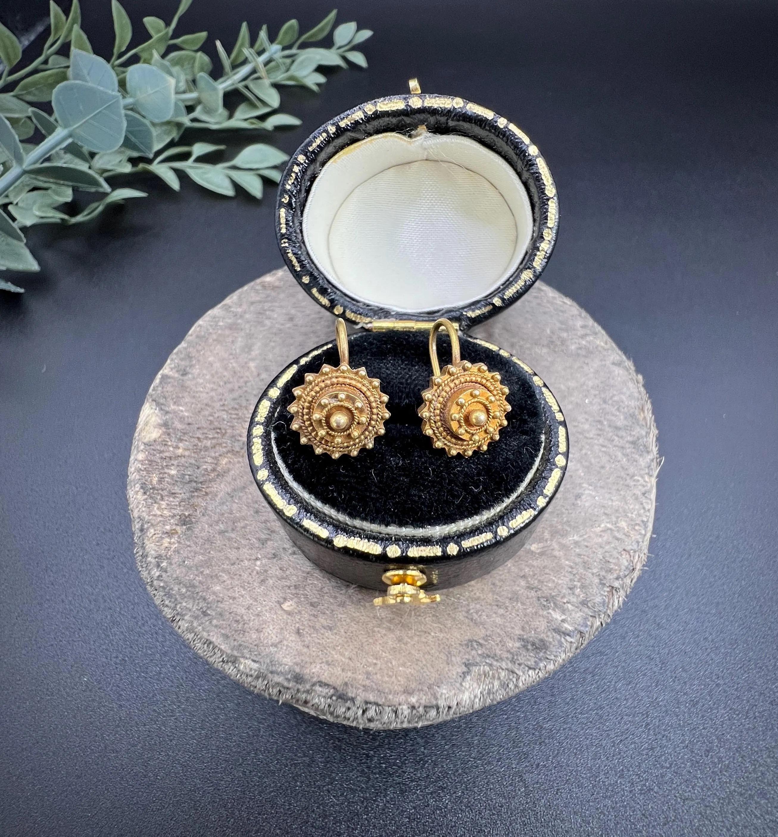Antique Gold Earrings

15ct Gold

Circa 1880

Discover a pair of exquisite Victorian round drop earrings, crafted from 15ct gold and adorned with intricate Etruscan gold work. These stunning earrings showcase a beautifully detailed design that