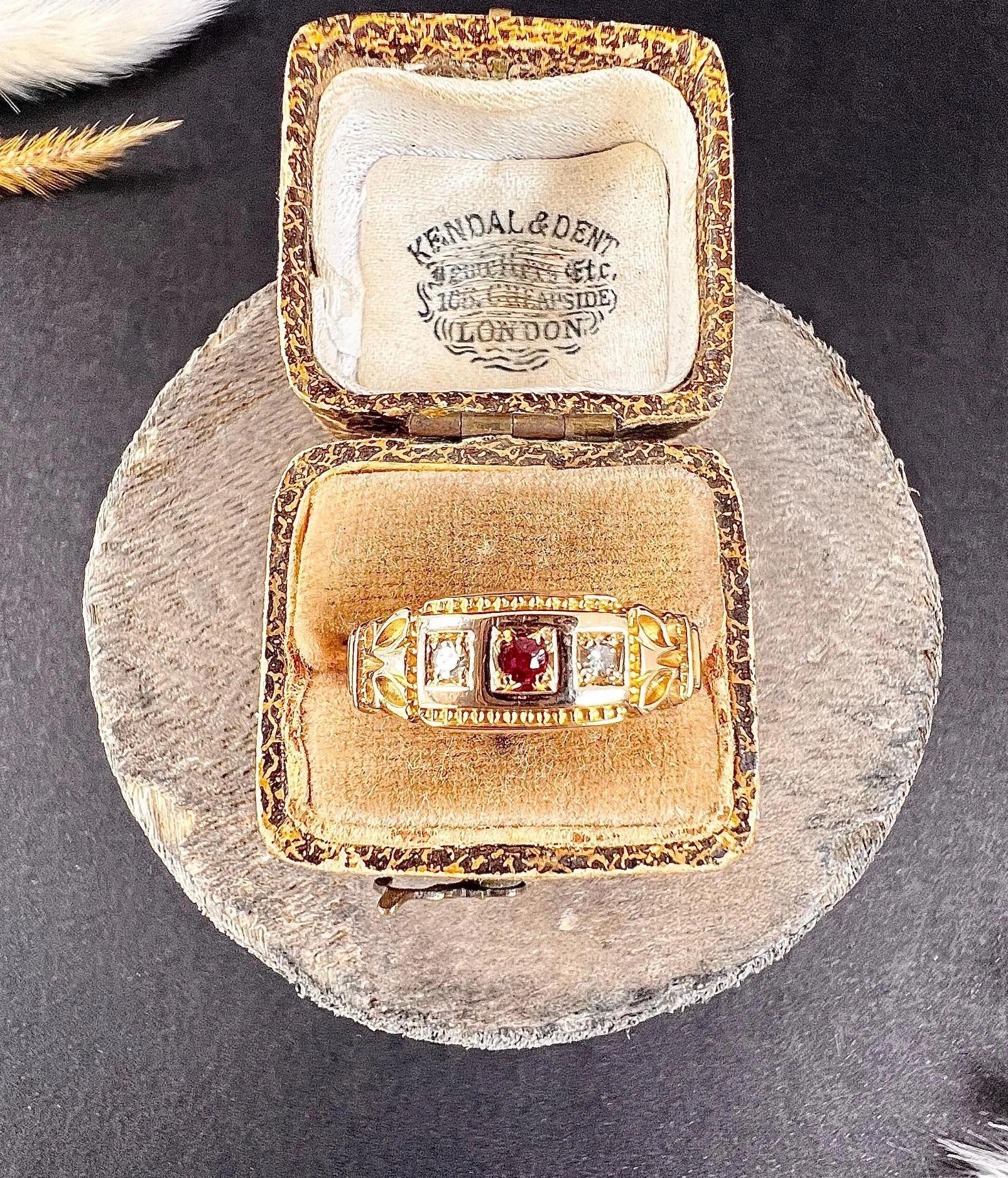 Antique Ring 

15ct Gold Stamped 

Hallmarked Chester 1891

Makers Mark H

Introducing a stunning 15ct gold Victorian 3-stone ring, adorned with a central ruby and a diamond on each side. The ring boasts a charming crimped edge, exquisite