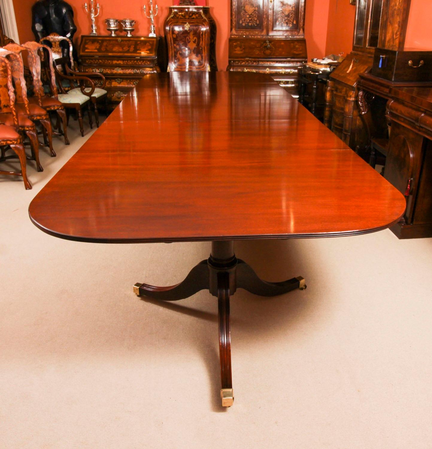 Il s'agit d'une fabuleuse table de salle à manger antique à triple piédestal de style George III datant du début du 20e siècle.

Le plateau de la table aux angles arrondis est en acajou flammé et repose sur trois colonnes tournées en 