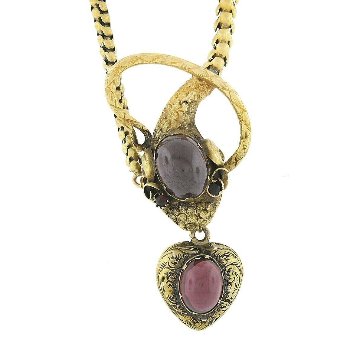 Here we have an incredible antique necklace crafted in solid 18k yellow gold and features a magnificent snake necklace adorned with fine garnet stones. The snakes head is set at the center of the necklace with a puffed heart gently dangling from its