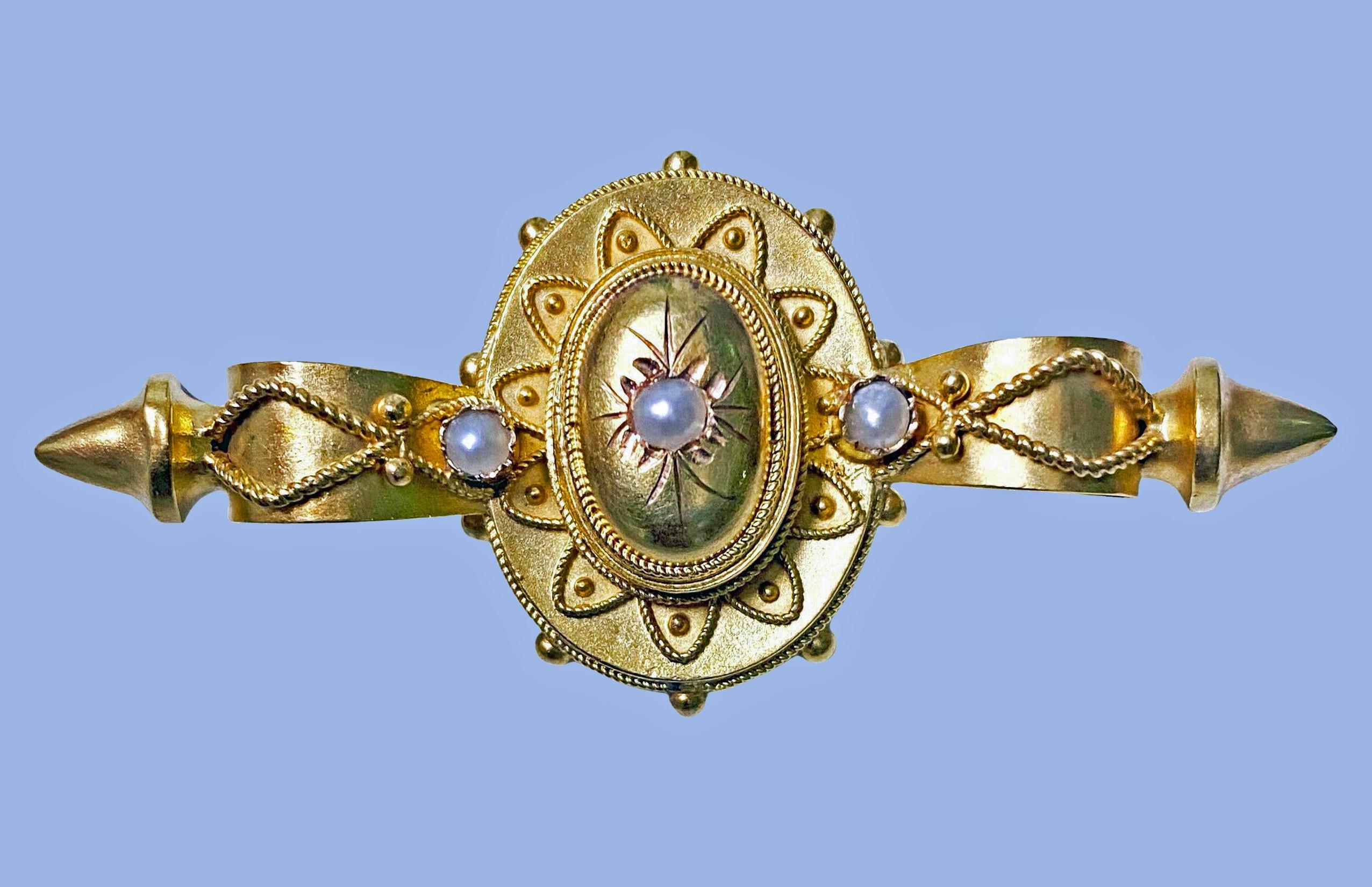 Antique 19th century 15K pearl Etruscan pin brooch, English C.1875. The brooch set with three small pearls with etruscan surround decoration, acid matte finish gold, vacant locket to reverse. Acid tested for 15K. Measures: 2.00 x 0.75 inches. Item