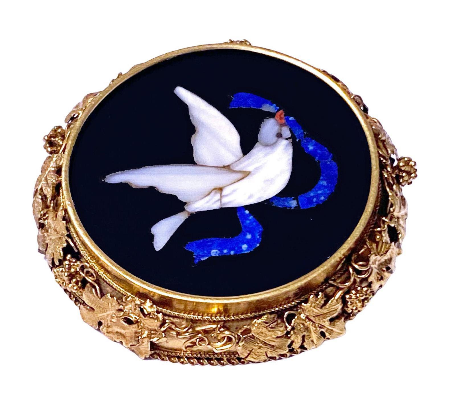 Antique 15K Gold Pietra Dura Pin, depicting a dove carrying a ribbon, mixed white, grey, blue and red on black onyx; frame with applied grape leaf motifs. Diameter: 3.50 cm . Item Weight: 9.44 grams.