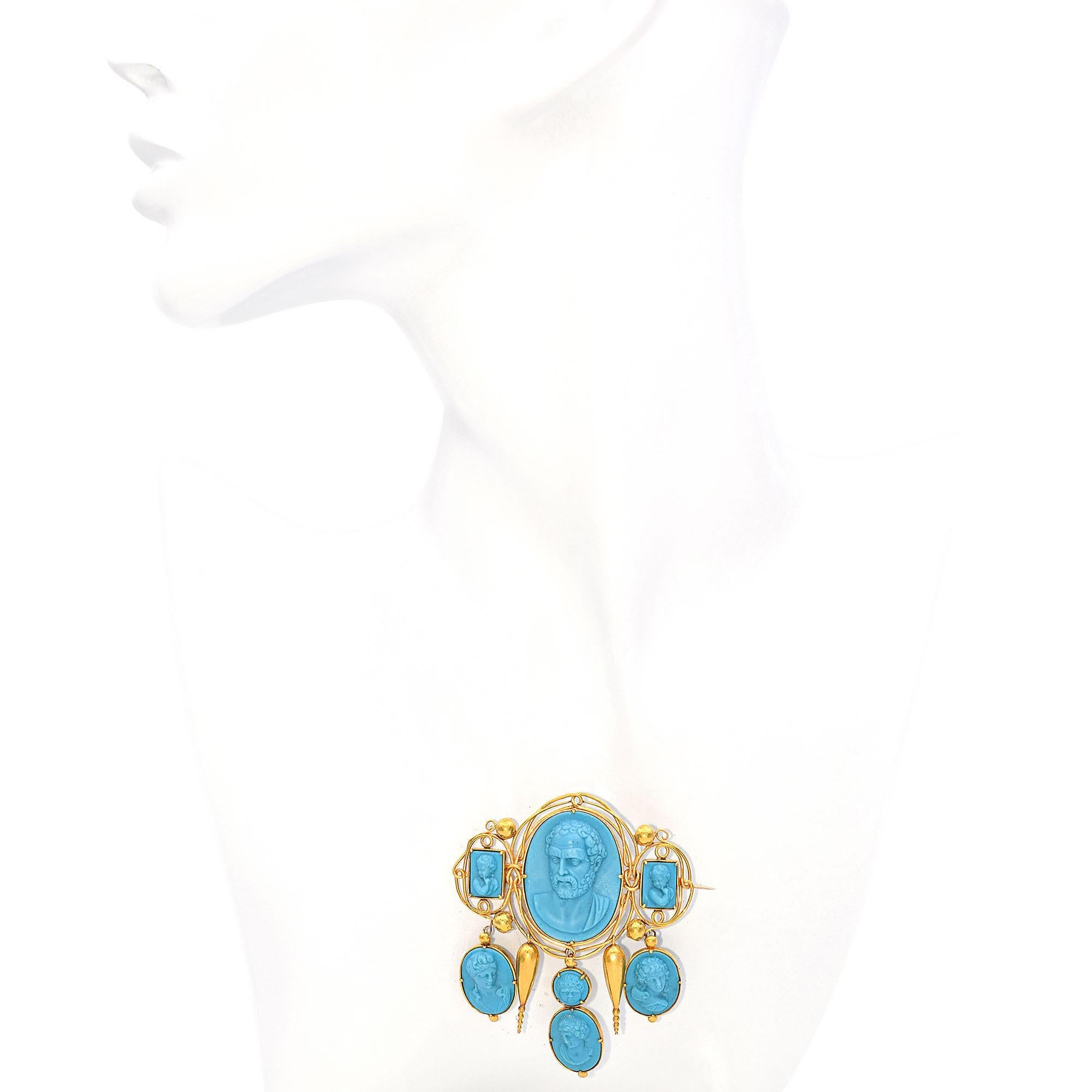 A remarkable turquoise and gold brooch from the 19th century. This exquisite piece is crafted in 15k yellow gold, featuring a captivating arrangement of blue turquoise cameos.
At the center is a prominent oval cameo depicting Demosthenes, Greek