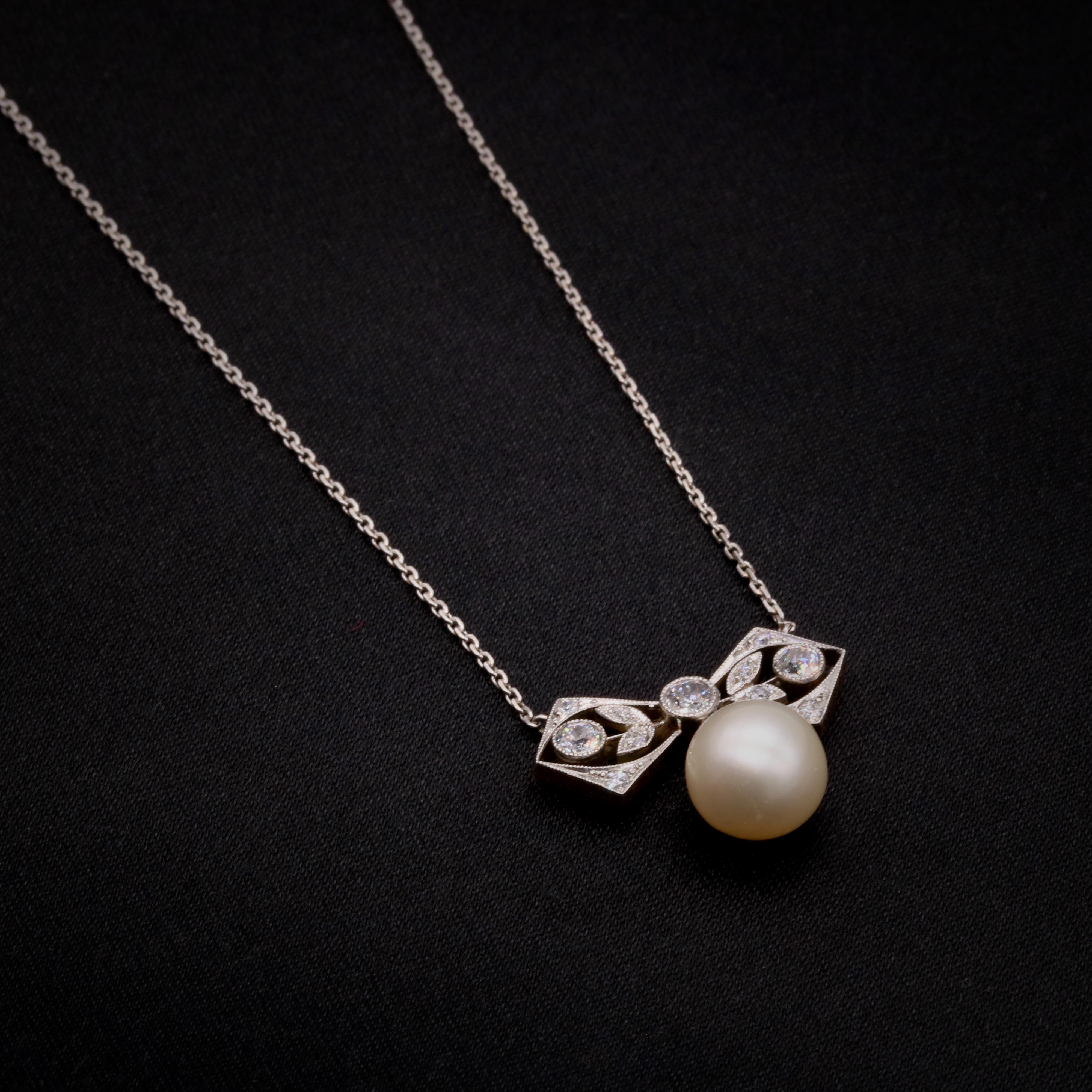 A Belle Epoque pearl, diamond, platinum, and yellow gold necklace, comprising one large, round pearl, three old European cut diamonds, and eight old single cut diamonds, set in platinum, backed in 15 karat yellow gold, with a platinum chain.  

This
