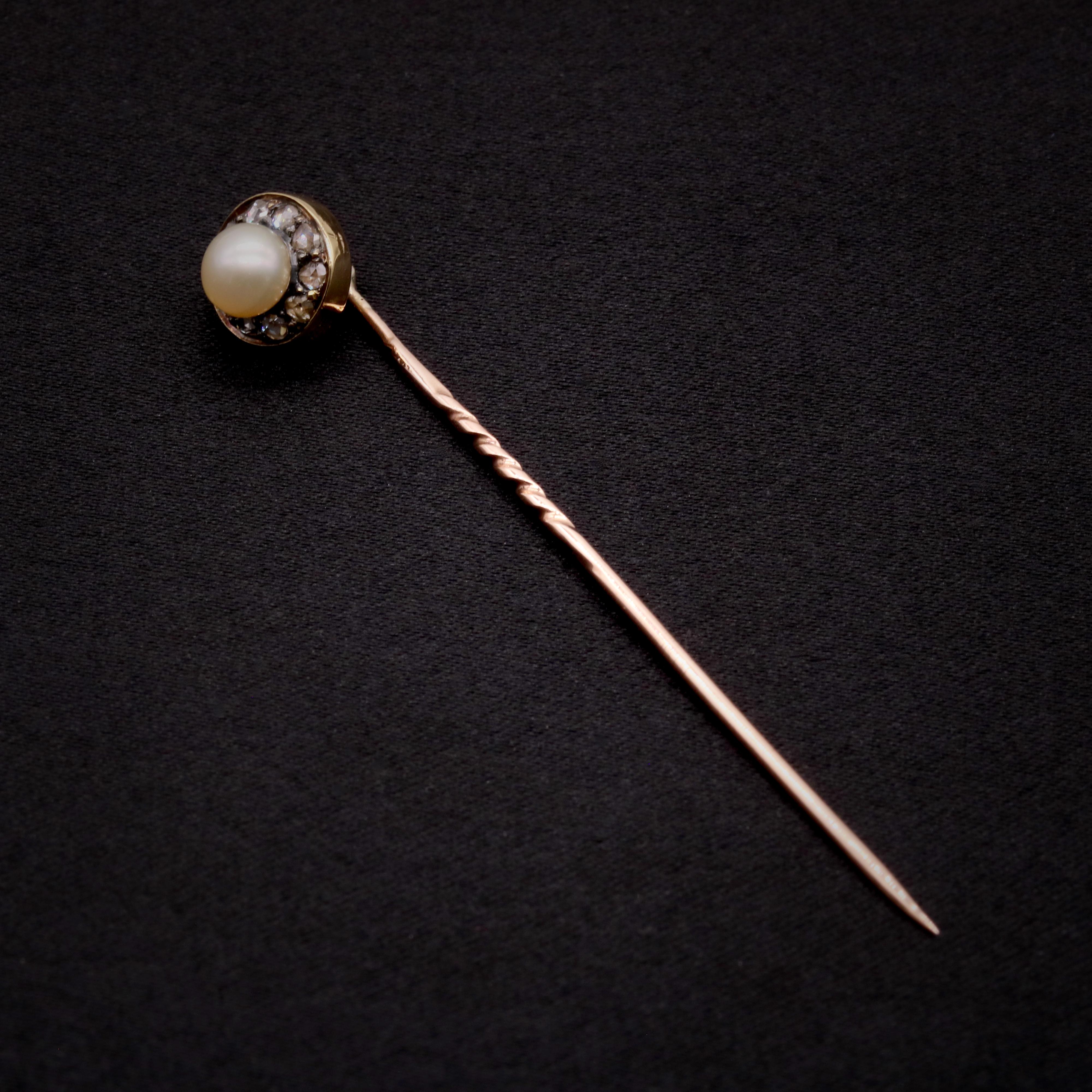 An antique diamond, pearl, silver and yellow gold stick pin, one round pearl, and ten rose cut diamonds, set in silver, in 15 karat yellow gold and 9 karat yellow gold. 

This lovely stick pin is circular in design, centred around a round button