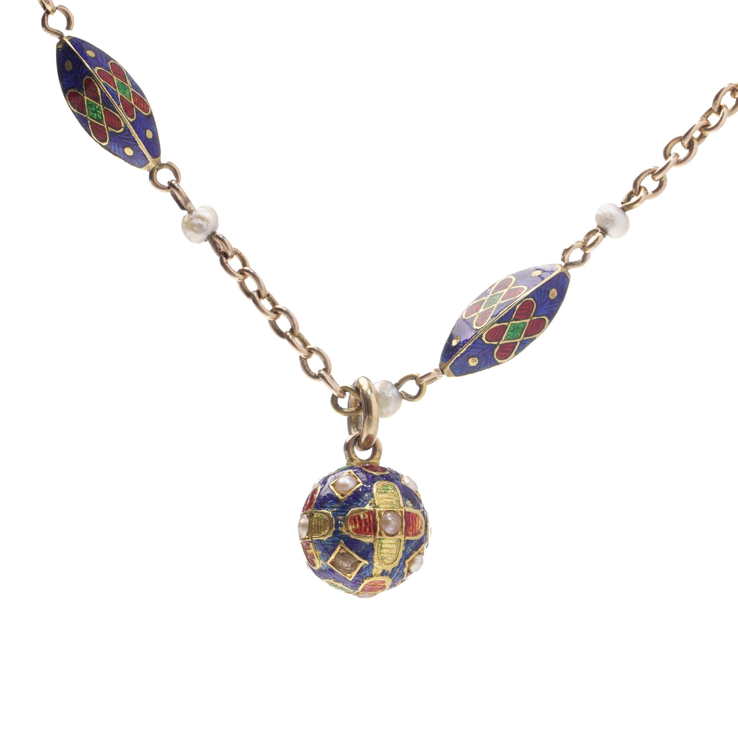A finely crafted antique bracelet composed of 15kt yellow gold with vivid multi-colour guilloché enamel work and seed pearls throughout. The bracelet features five navette-shaped enamel links in blue, red, green, and white, joined by a gold chain