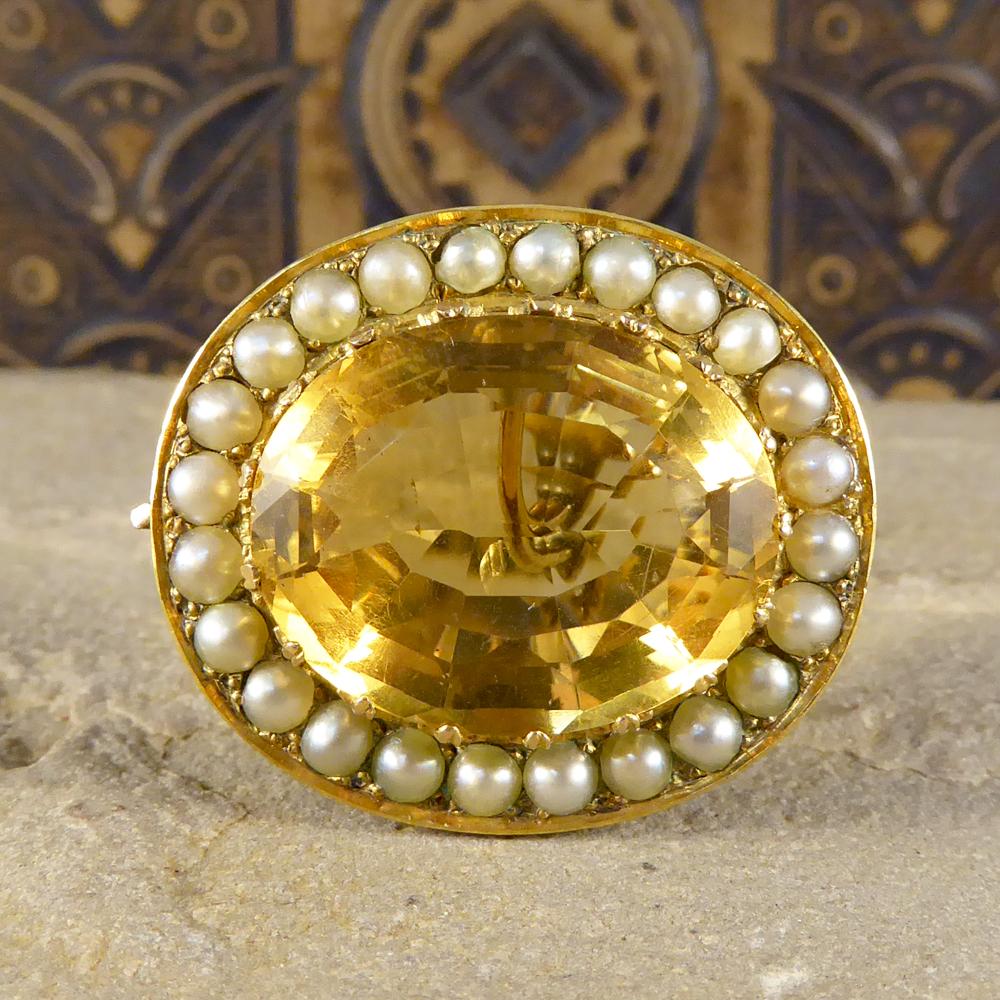 The gorgeous antique piece can be used as both a Brooch and Pendant with the seed Pearl adorned bail being easily removable. Crafted in the Late Victorian era, this antique piece holds a large Citrene gemstone weighing approx 16ct with a halo of