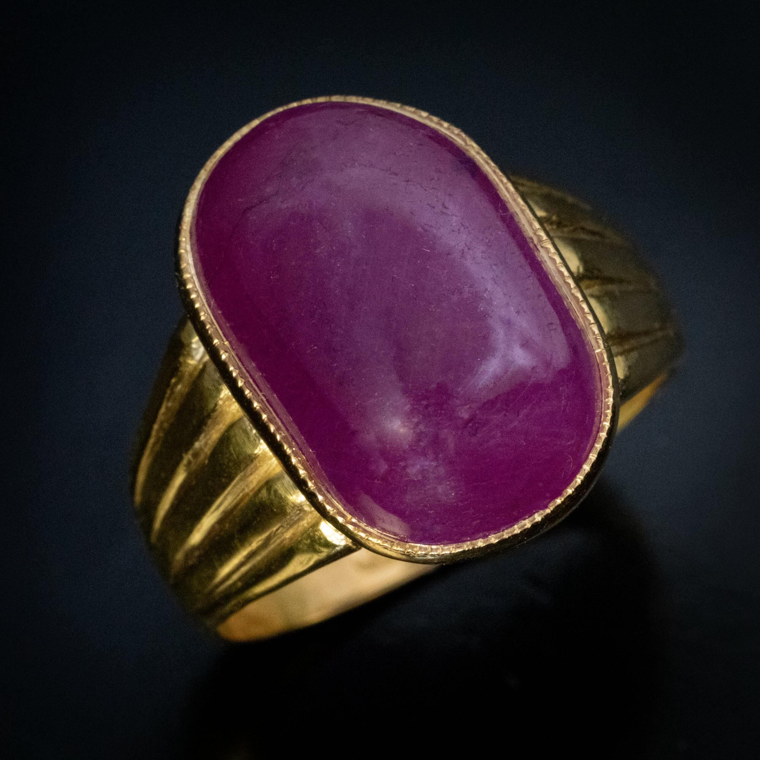 Moscow, 1866  This impressive Russian antique ring is crafted in 23K gold (95.55% pure). It features an old mine cabochon-cut pink sapphire of notable size and soft, glowing luster. 
The sapphire is set in a fine bezel, allowing the gemstone’s