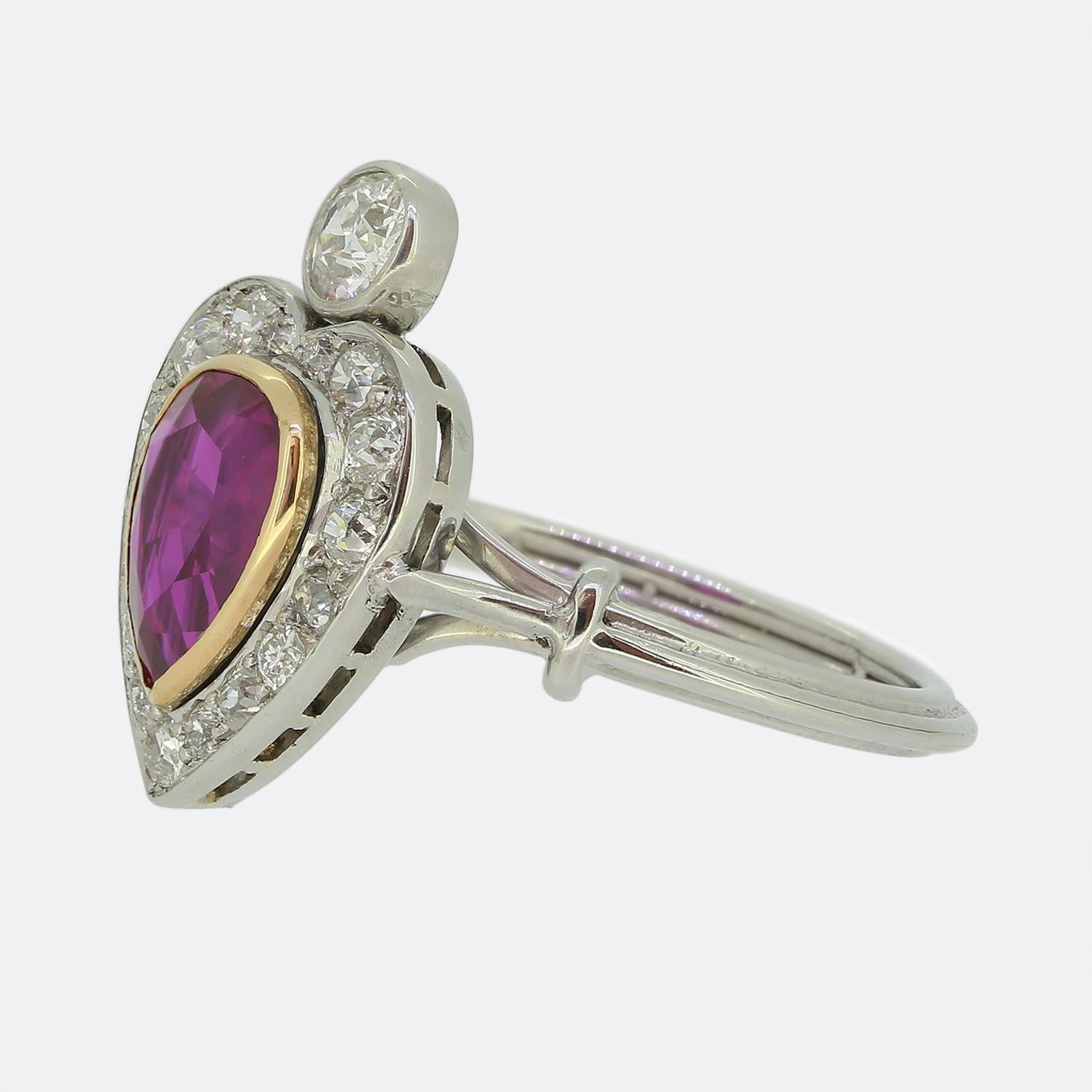 Aquí tenemos un sensacional anillo en racimo, meticulosamente elaborado en platino. En su centro se encuentra un llamativo rubí de origen birmano tallado en forma de corazón, que irradia un tono rojo intenso con un ligero matiz rosado, elegantemente