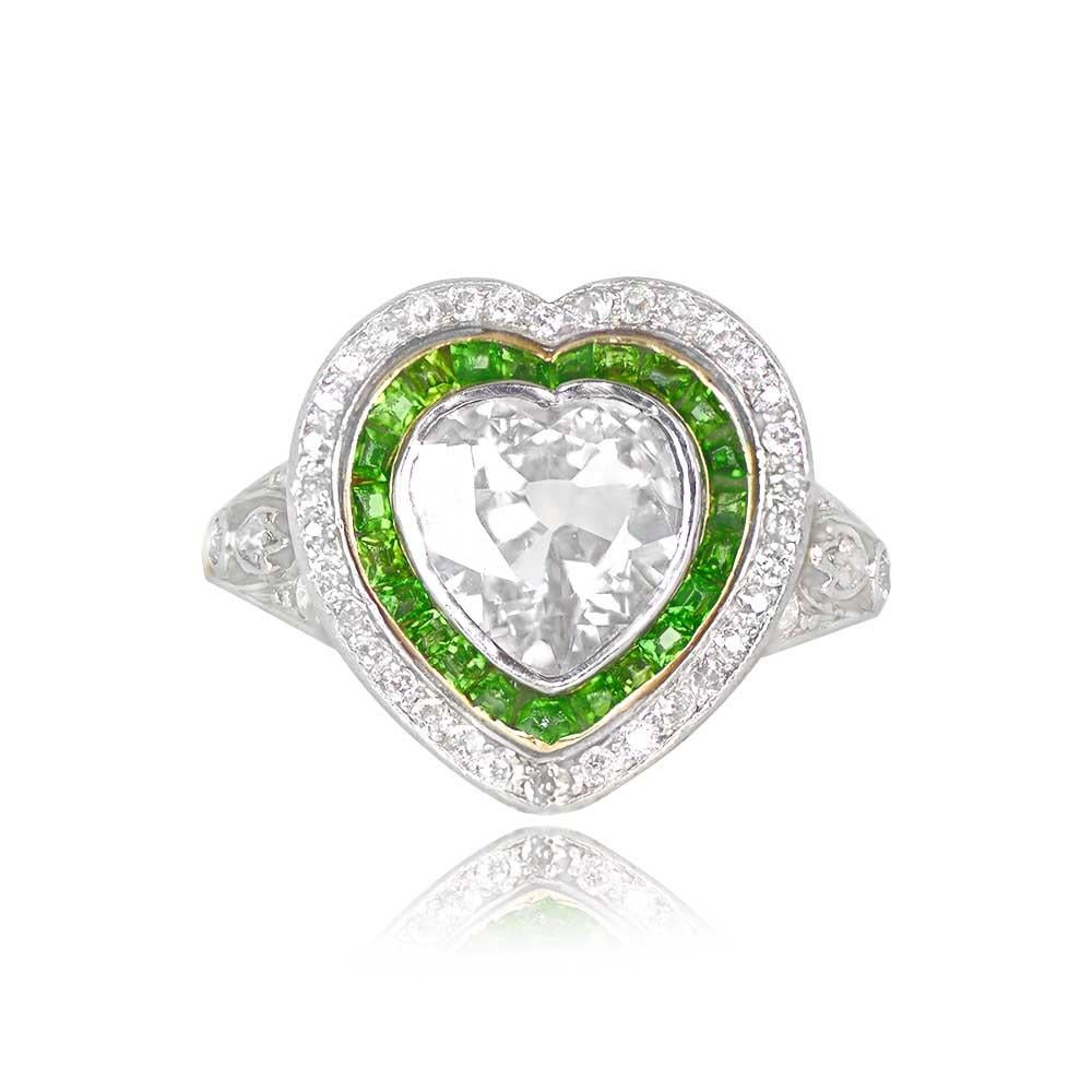This antique Edwardian-era ring showcases a remarkable 1.60-carat heart-shaped diamond with G color and VS2 clarity at its center. The heart-shaped diamond is elegantly encircled by a double halo crafted from calibre-cut tsavorite garnets and