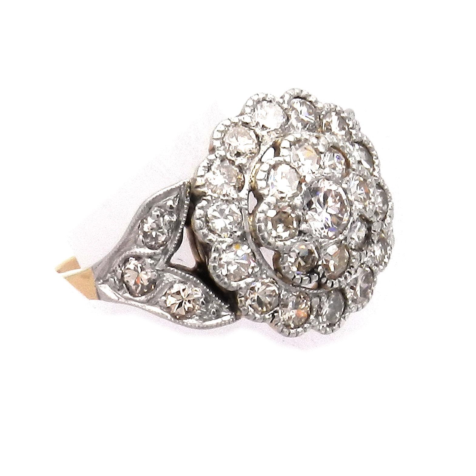 Antique 1.65 Carat Diamond 14K Gold and Platinum Ring circa 1910

Very decorative diamond ring with a flower-shaped ring head made of yellow gold and platinum, the stepped rosette set with 23 radiant old-cut diamonds, flanked on the sides by leaves