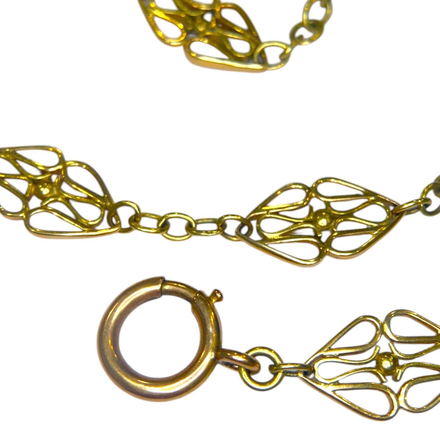 Magnifique chaîne de montre ancienne en or jaune 16 carats, composée de longs maillons en forme de navette arrondie avec des torsades intérieures et des fermoirs en or rose. L'anneau à ressort tient très bien, et le fermoir en forme de pince à chien