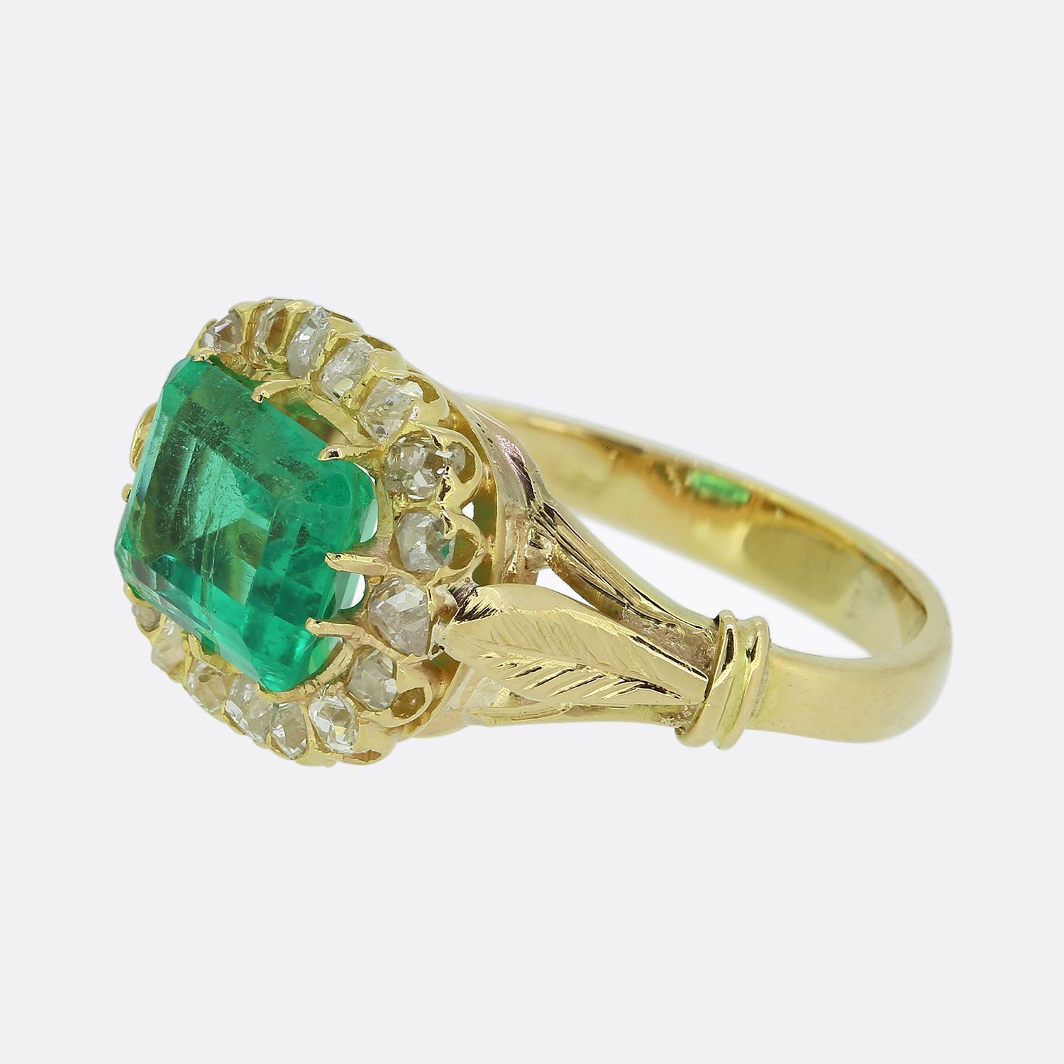 Ecco uno splendido anello antico a grappolo con al centro uno smeraldo colombiano dal taglio accattivante. La vibrante pietra principale verde è splendidamente completata da una cornice di diamanti taglio old mine intorno al bordo esterno del