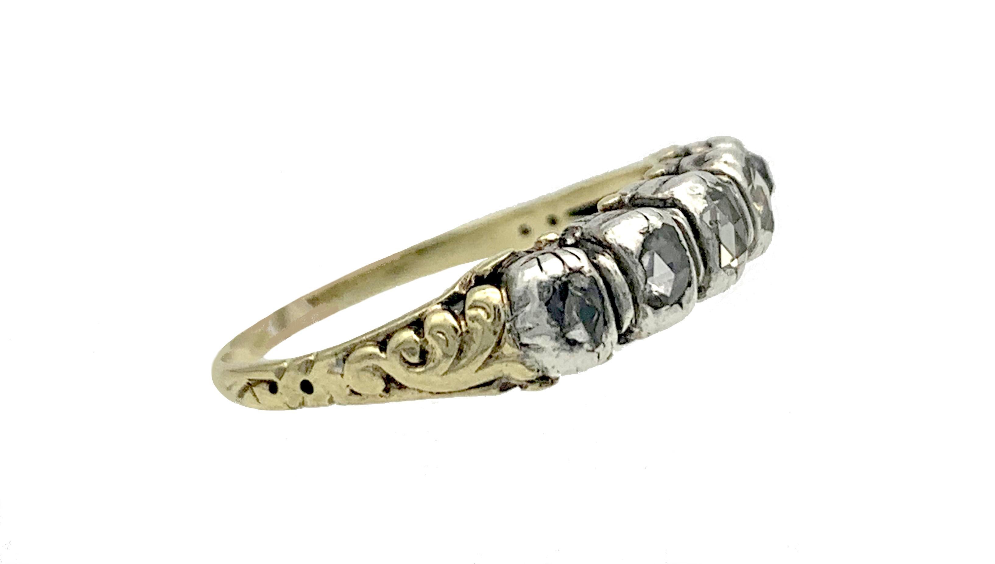 This sentimental diamond ring was created in the 18th century. Five old cut diamond roses are mounted in silver onto a gold ring engraved at the back. Each diamond is engraved on its reverse with a pansy. The ring was most certainly a love token.
