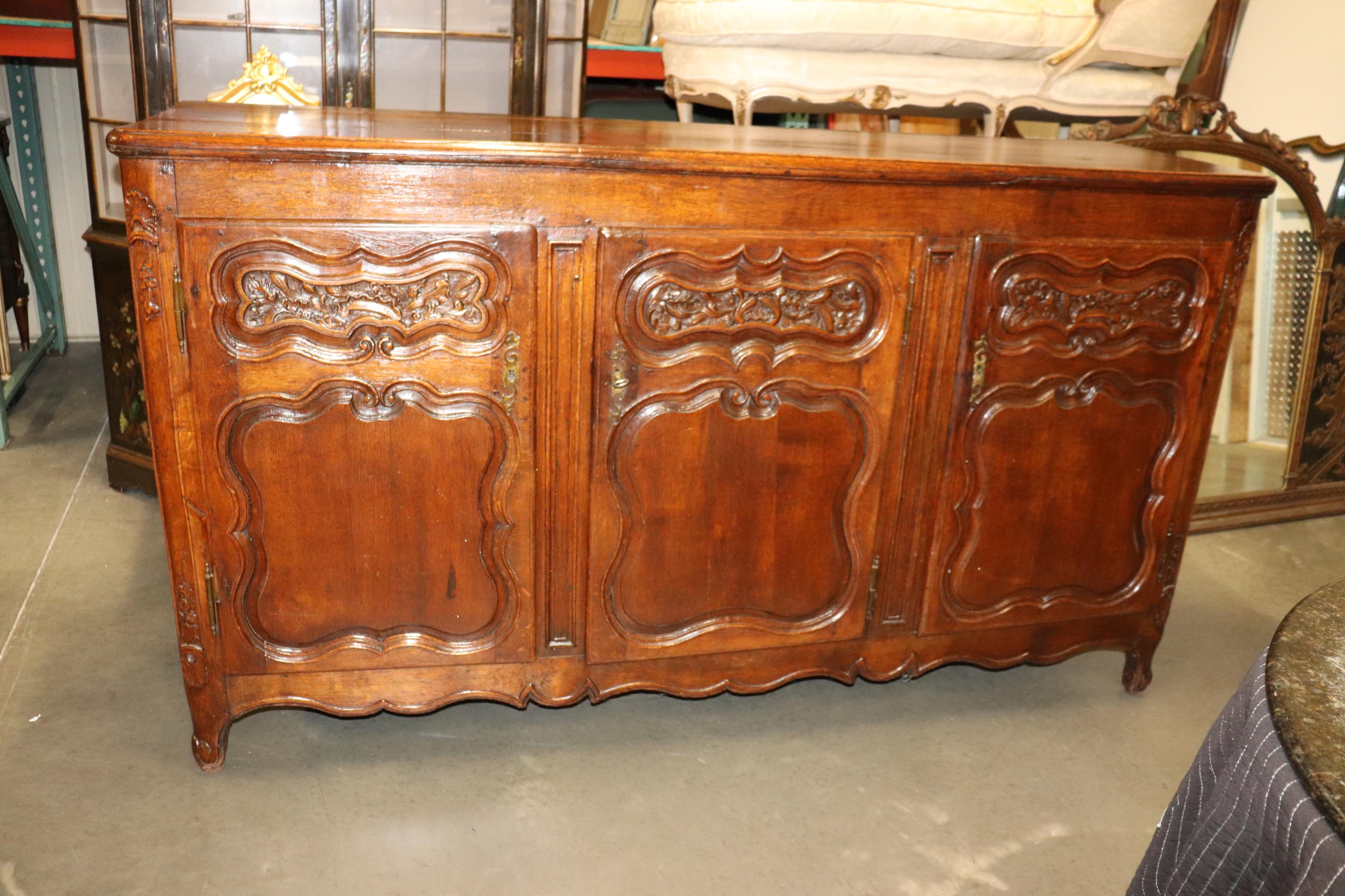 This is a gorgeous French country carved walnut sideboard with hand-hewn backboards and tons of character and age. The size is on the grander scale at 80 wide x 23 deep x 45 tall and the condition is good considering the age and will show time-worn