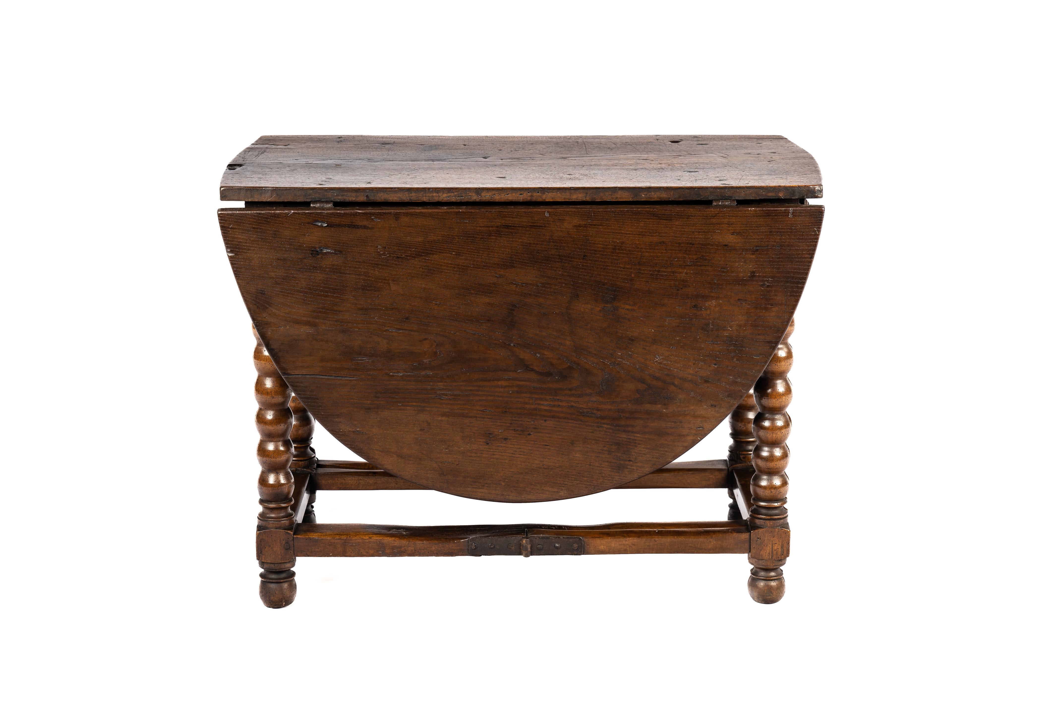 On offer here, is an exquisite piece of history—an antique gateleg or dropleaf table originating from Spain, dating back to the late 17th century, circa 1680. This remarkable table is crafted from solid chestnut wood, boasting a stunning grain