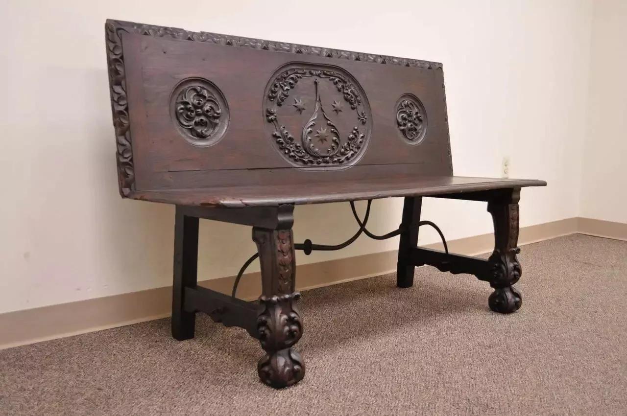 Banquette en chêne sculpté et fer forgé de la Renaissance anglaise du 17e siècle. Le dos et les pieds sont sculptés à la main en profond relief et se terminent par des pieds avant en forme de griffes. La base est soutenue par un châssis en fer forgé