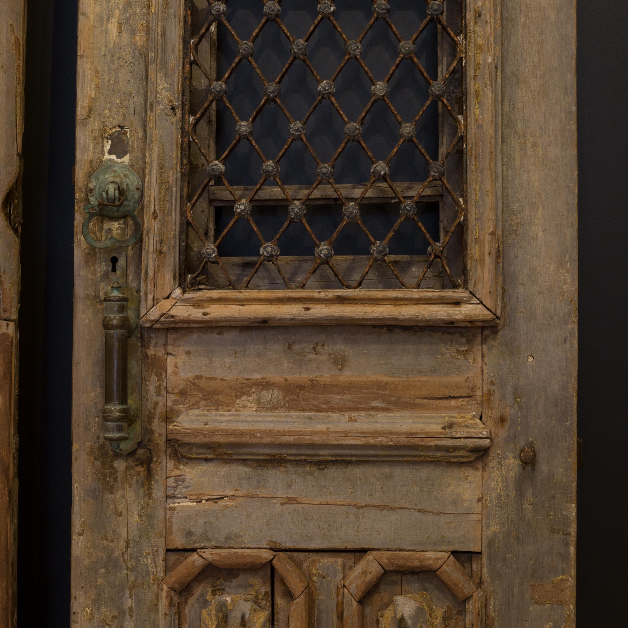 About

This a pair of original wooden castle doors with steel grate and substantial bronze hardware. The doors feature intricately carved heads of the man and woman of the house positioned at the top of each door. Shutters are on the backside that