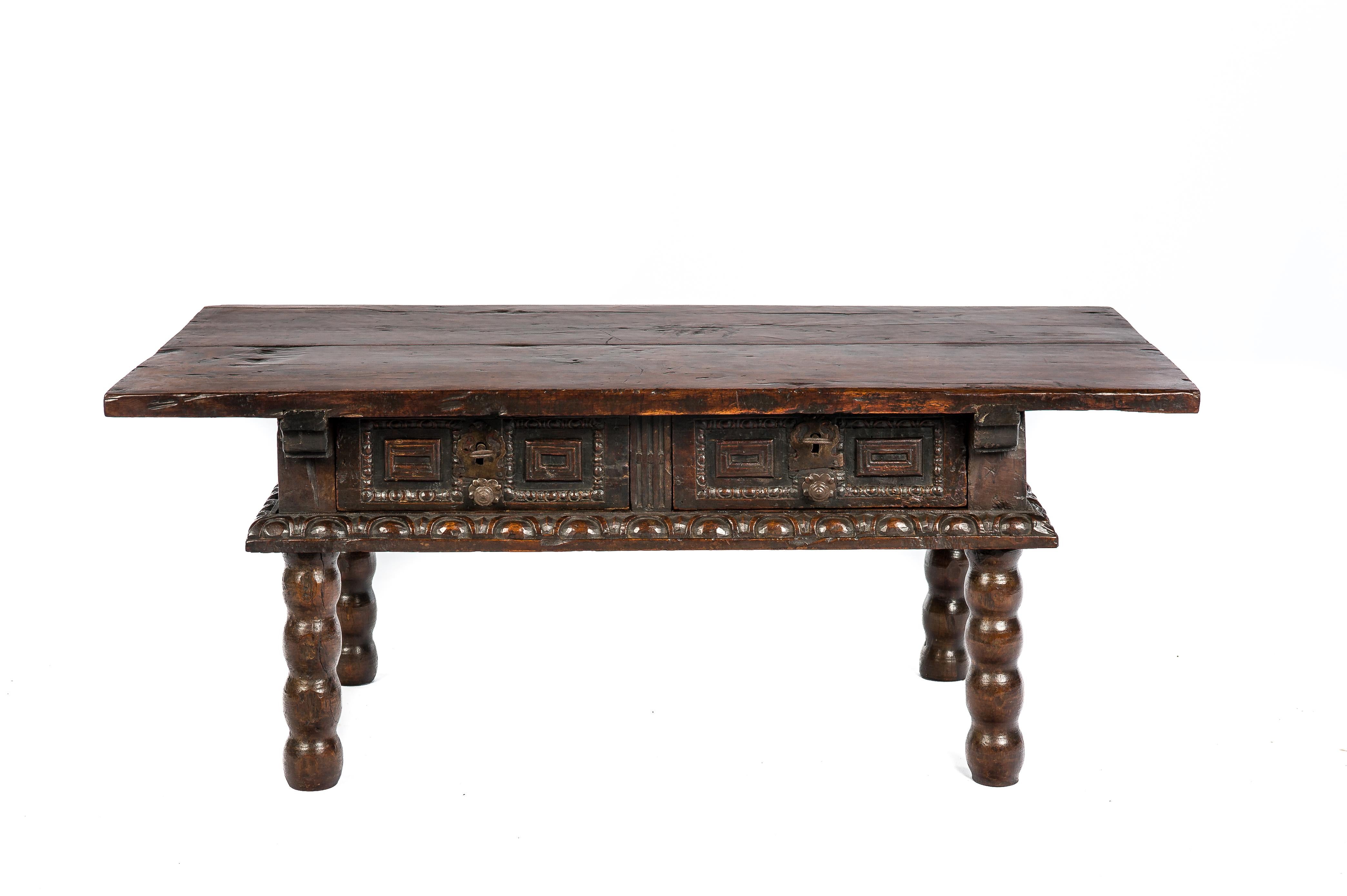 A rustic walnut coffee table that originates in Spain circa 1680.
Its top is made from two pieces of solid thick walnut with beautiful grain. Below two drawers are situated. The drawer fronts have a hand carved gadrooned mold and elevated panels.
