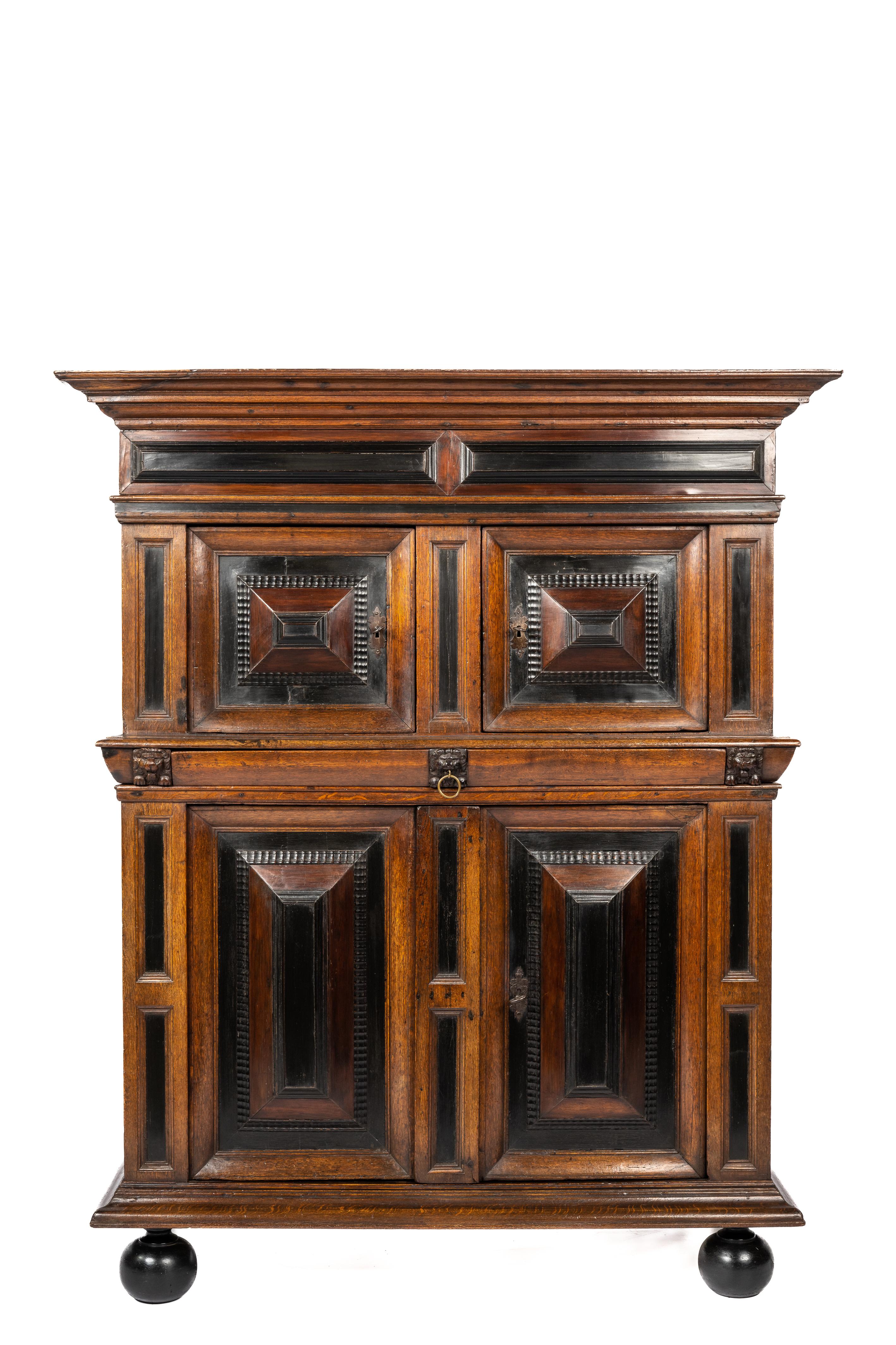 This beautiful and friendly-sized cupboard is made of the finest watered oak in the tradition of the Dutch Renaissance during the “Dutch golden age” It is a two-story four-door cabinet over ebonized bun feet. This cabinet is made in the Dutch