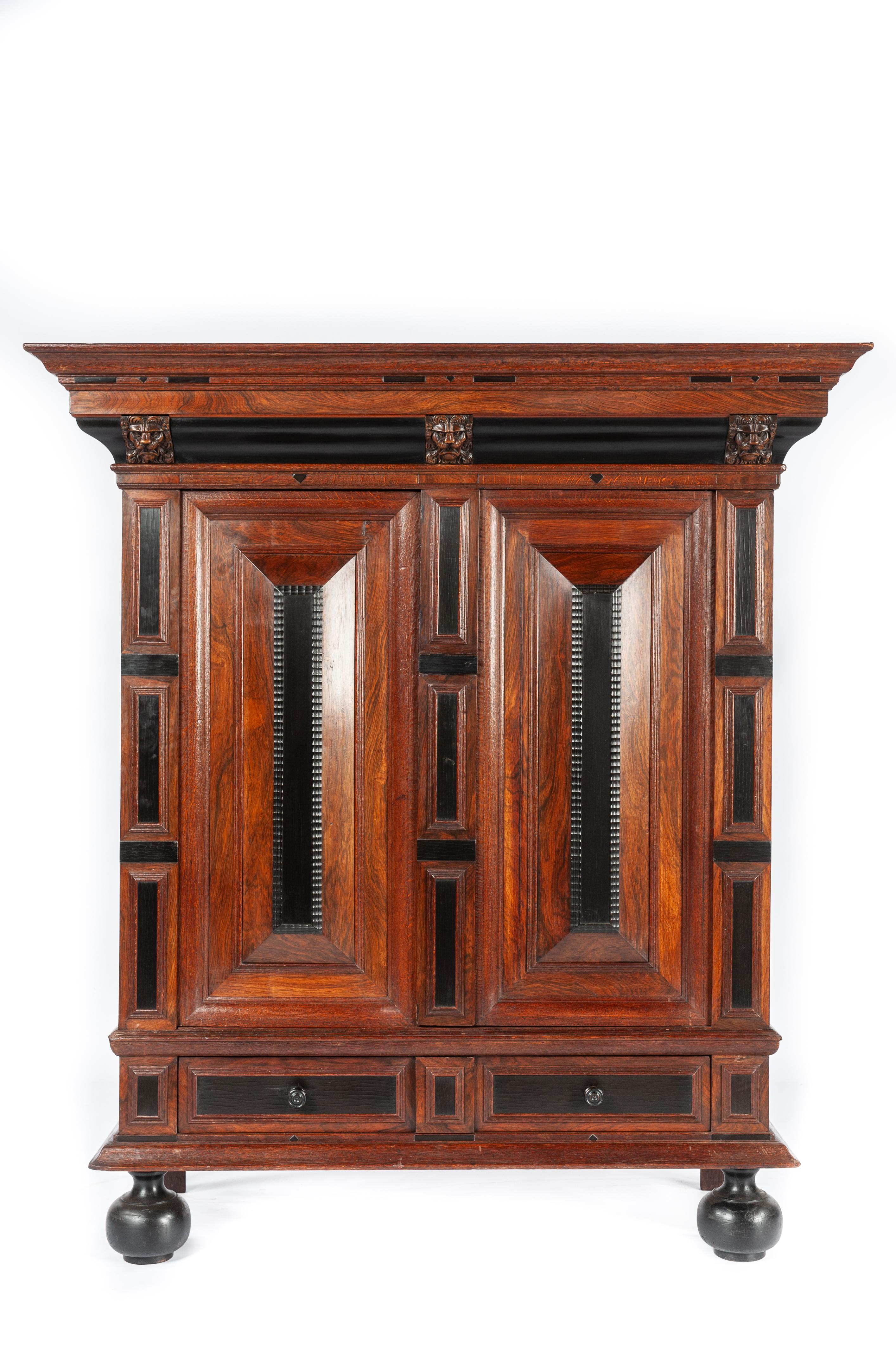 This beautiful and friendly-sized cupboard is made of the finest watered oak in the tradition of the Dutch Renaissance during the “Dutch golden age” It is a two-door cabinet over ebonized bun feet. This cabinet is made in the Dutch Provence of