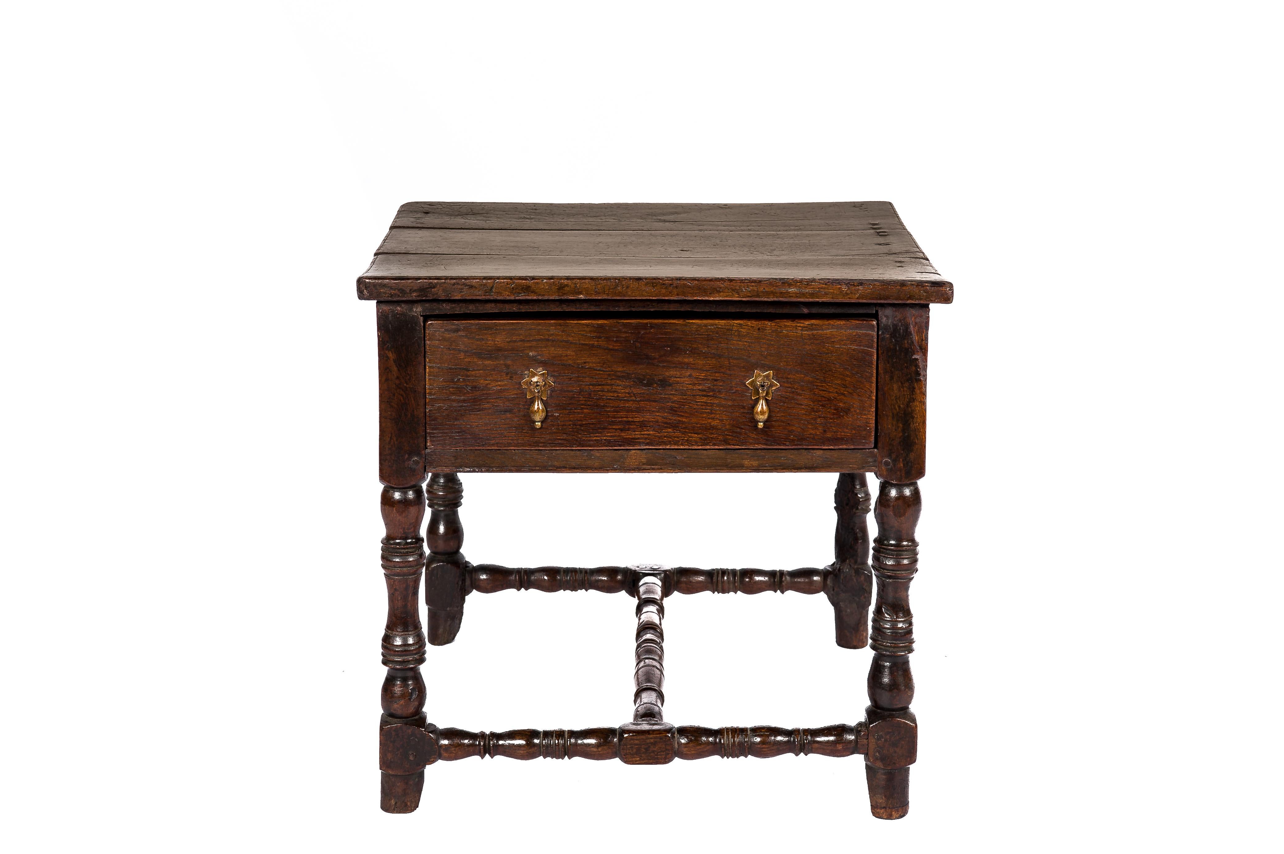 This is a fine-quality Charles II side table made in solid oak in the late 17th century. It has three plank bold top that was attached to the frame with wooden pens. The table has a single working full-length drawer, which features the original