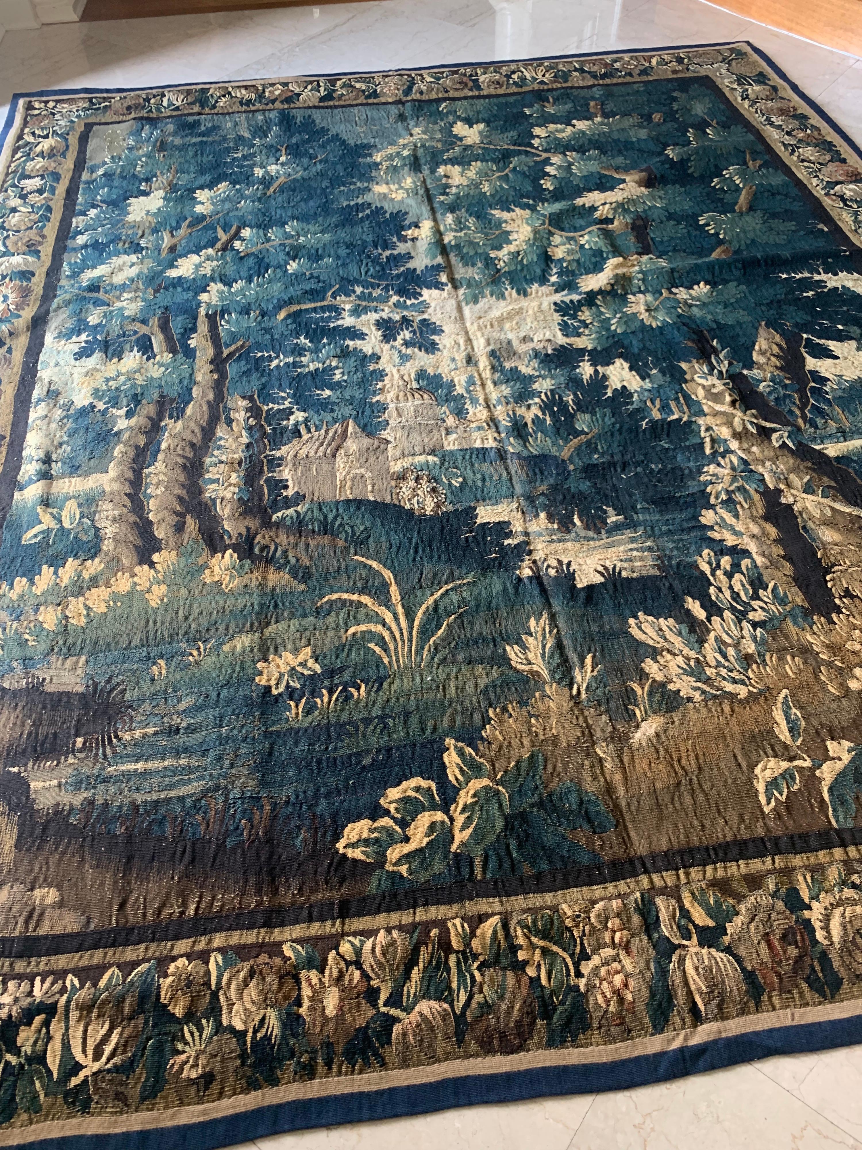 Dies ist eine herrliche antike quadratische 17. Jahrhundert flämischen Verdure Landschaft Wandteppich ohne Figuren in einer schönen und reichen Sommer-Szene einer Landschaft mit üppigen Bäumen und Vegetation und Häuser in der Ferne. Die Umrandung